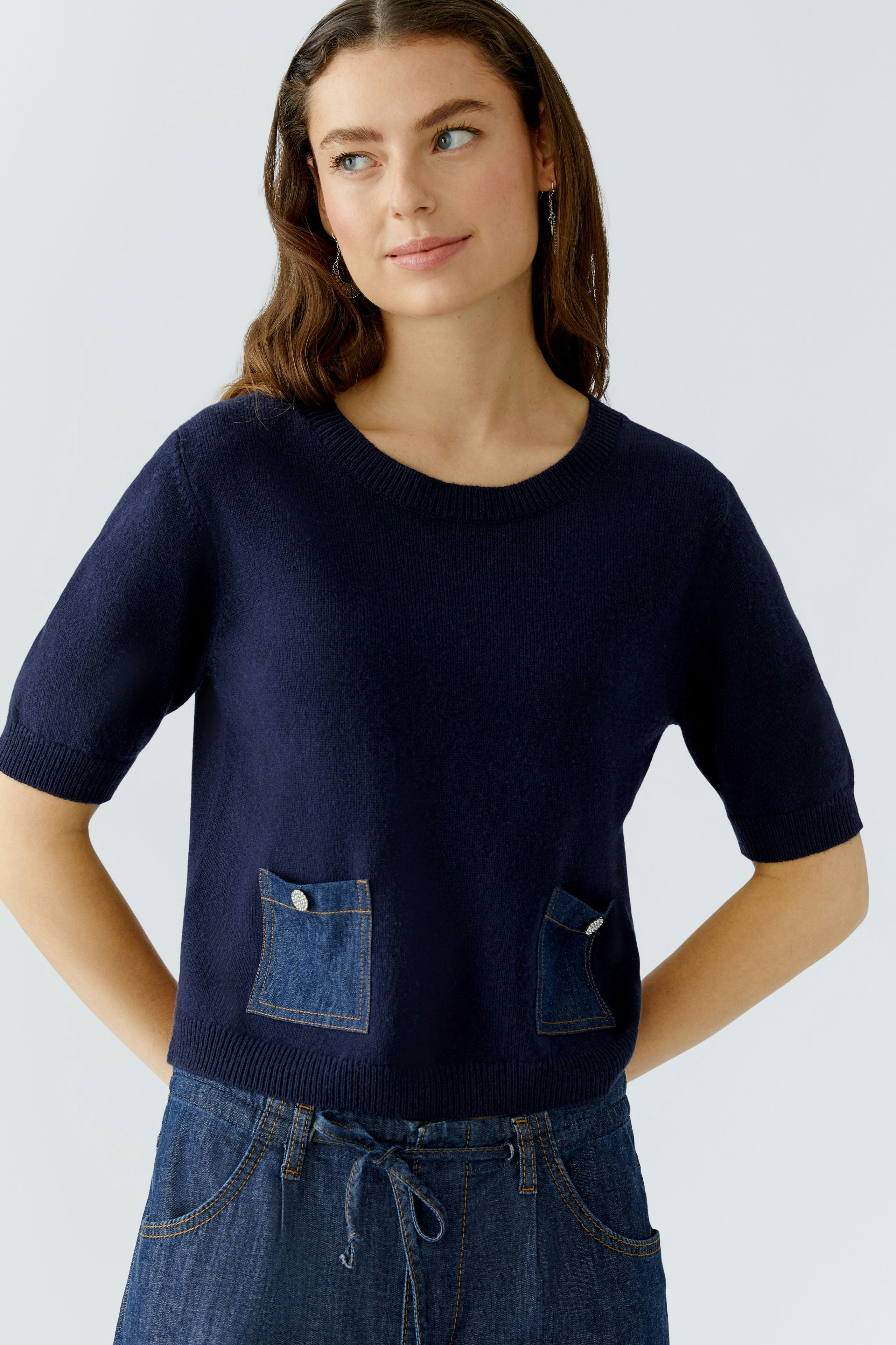 Damen-Pullover: Junge Frau in navy Pullover mit kurzen Ärmeln und Jeans-Taschen wirkt lässig und modern.