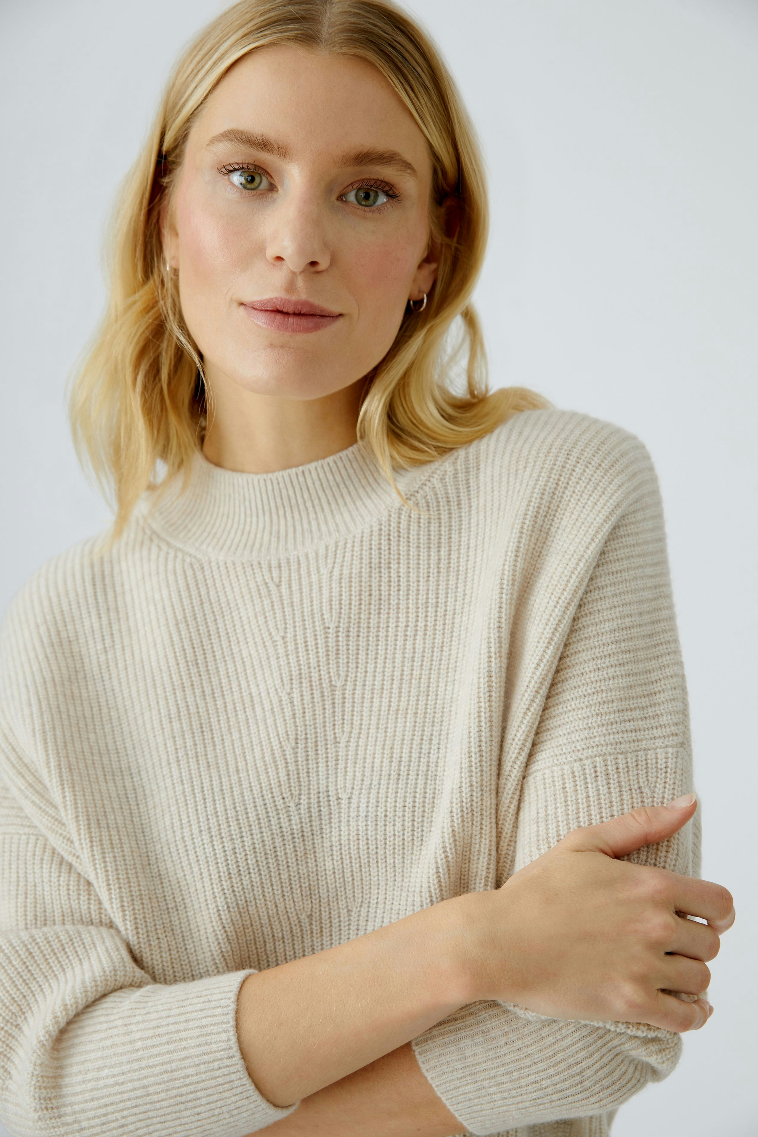 Beiger Damen-Pullover: Junge Frau mit lässigem, weichem Strickpullover und entspanntem Look.