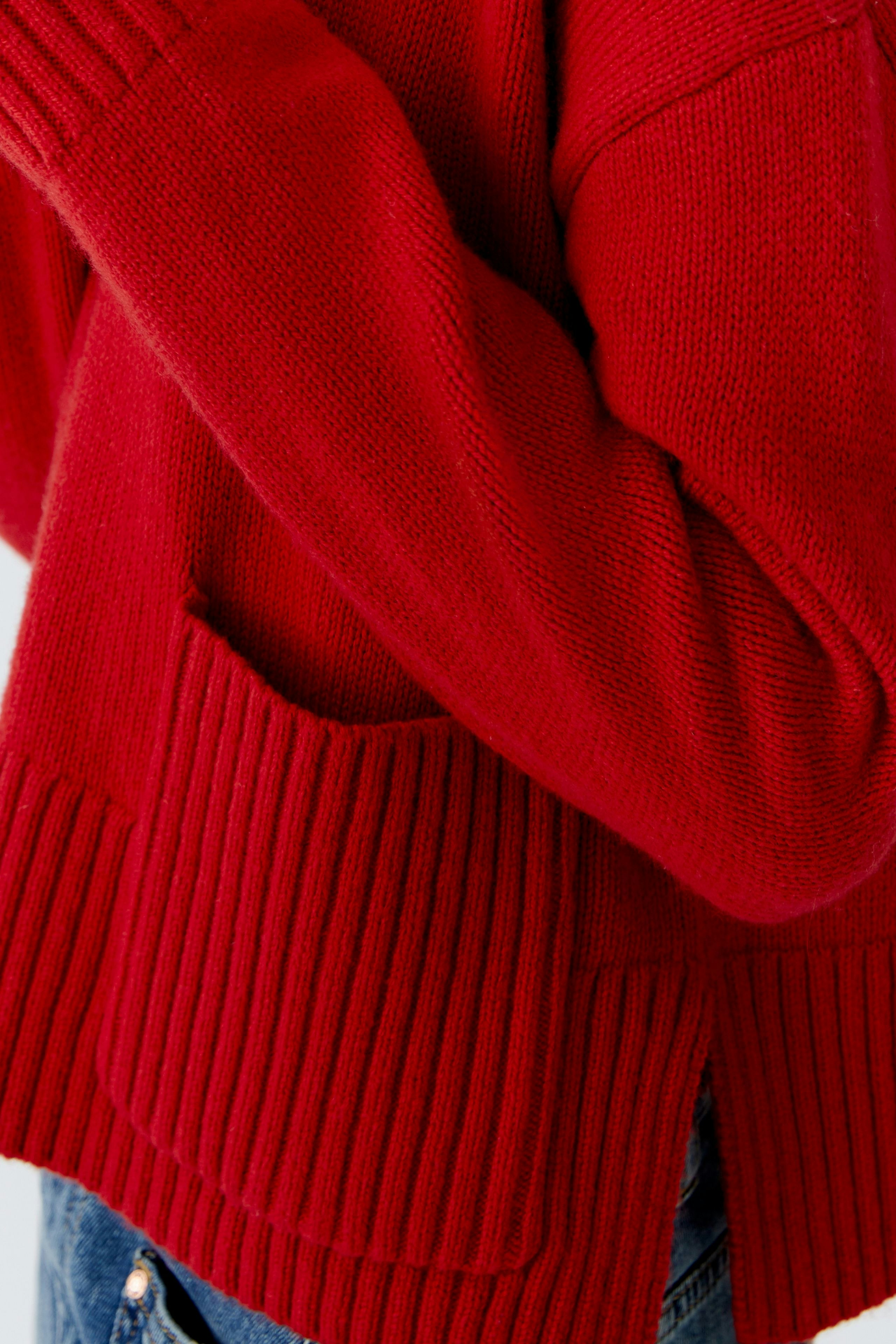 Casual women's pullover: A woman in a cozy red pullover with ribbed details and pockets.