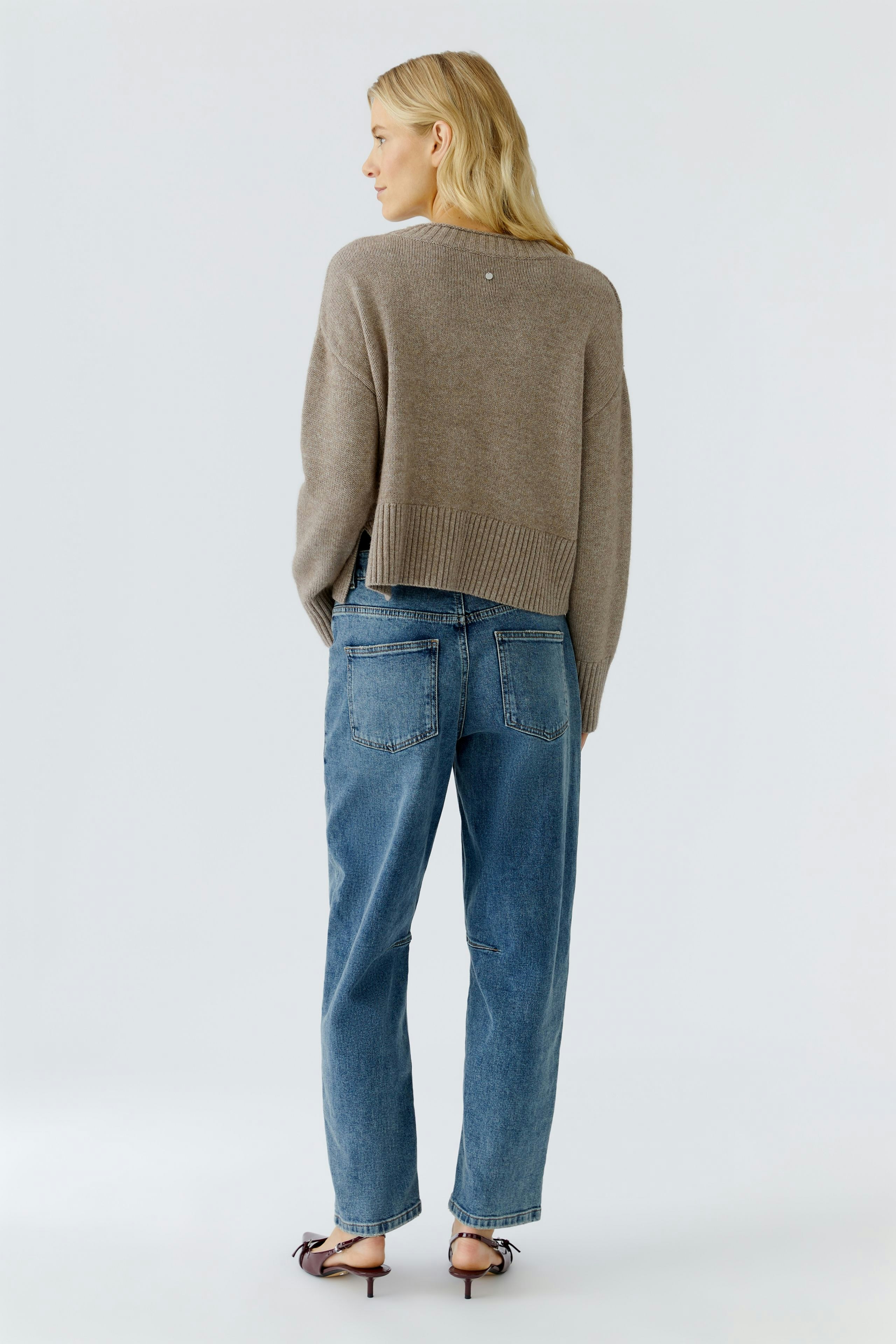 Casual women's pullover: A woman in a cozy brown pullover paired with relaxed blue jeans.