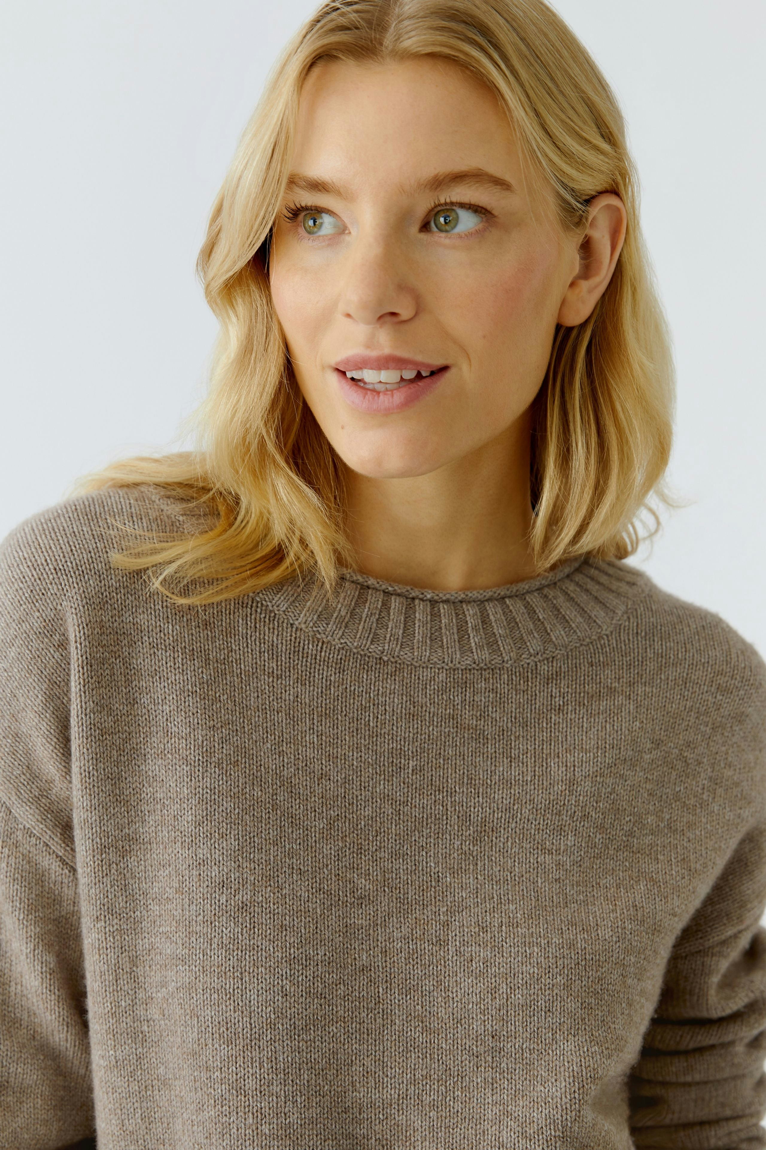 Casual women's pullover: Woman in a soft brown pullover with a round neckline, smiling confidently.
