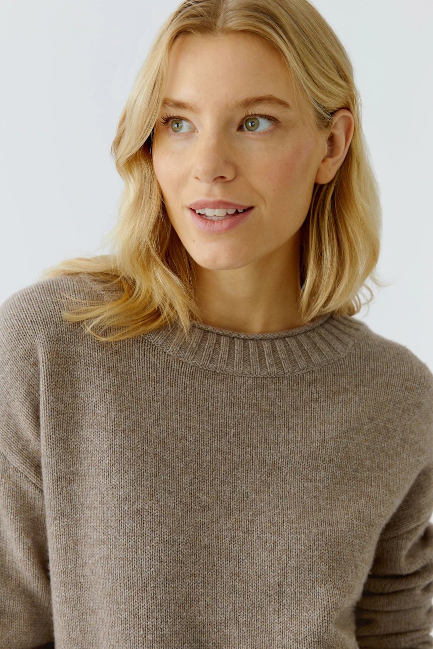 Casual women's pullover: Woman in a soft brown pullover with a round neckline, smiling confidently.