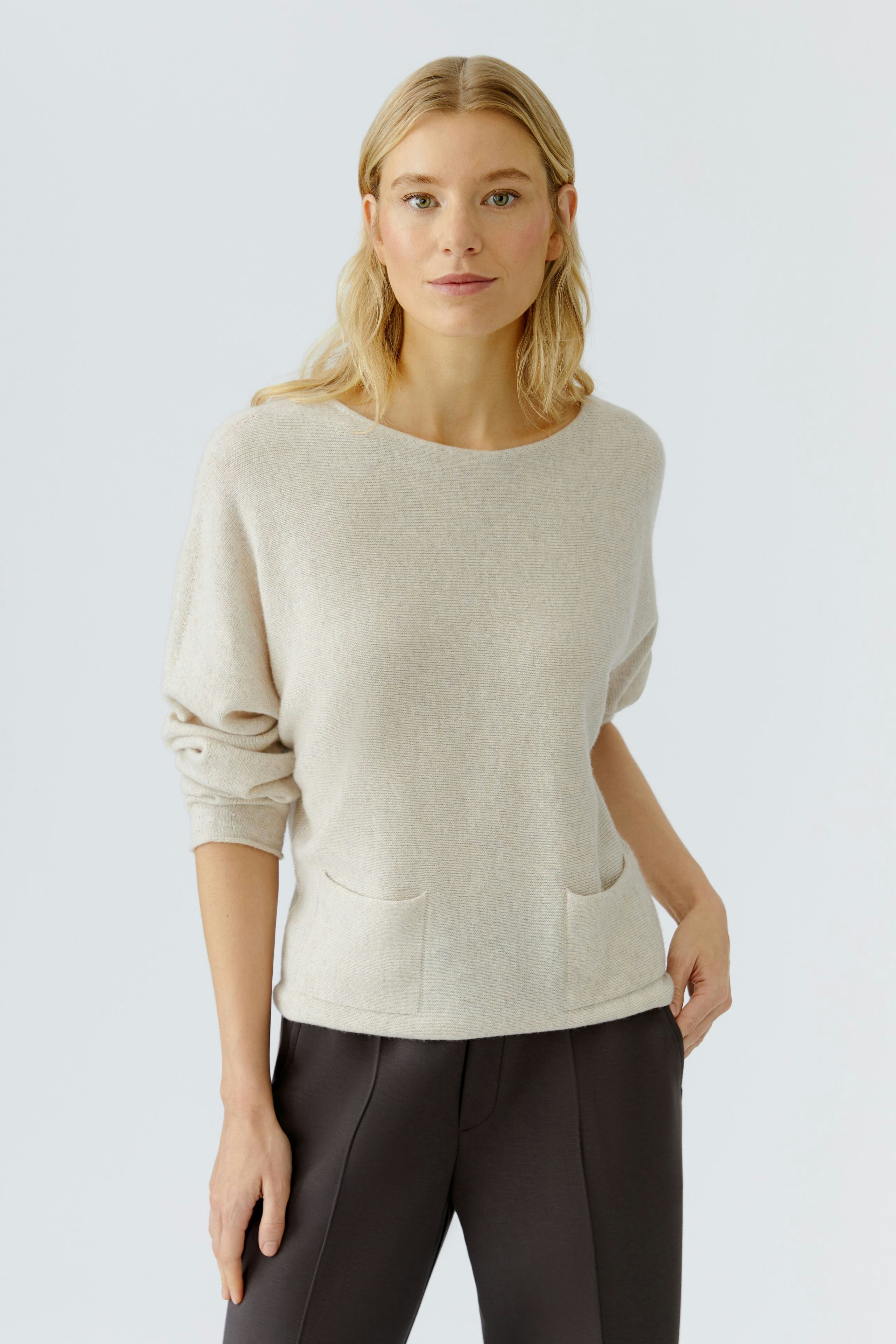 Casual women's pullover in soft beige with a relaxed fit and front pockets.