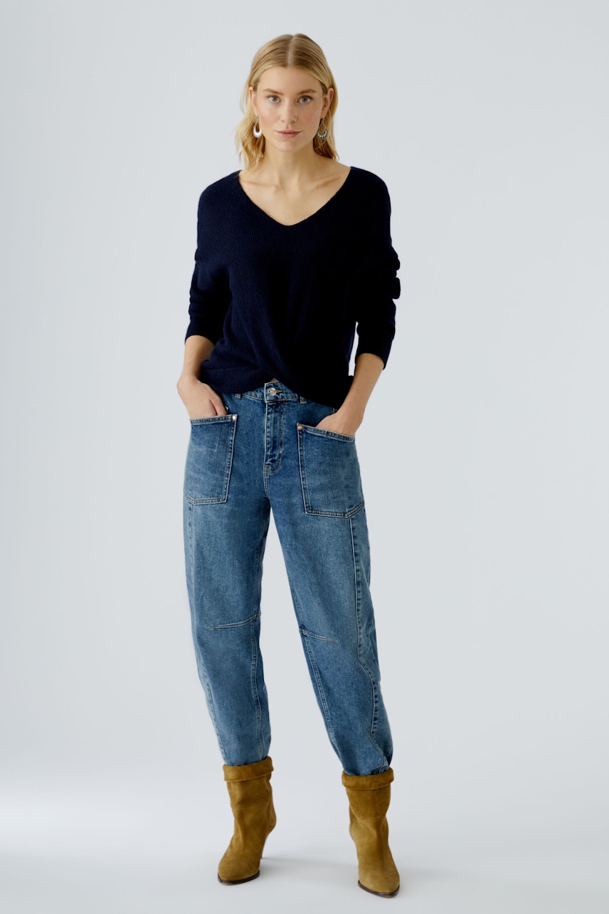 Casual women's pullover: A woman in a navy pullover with a relaxed fit and stylish jeans.