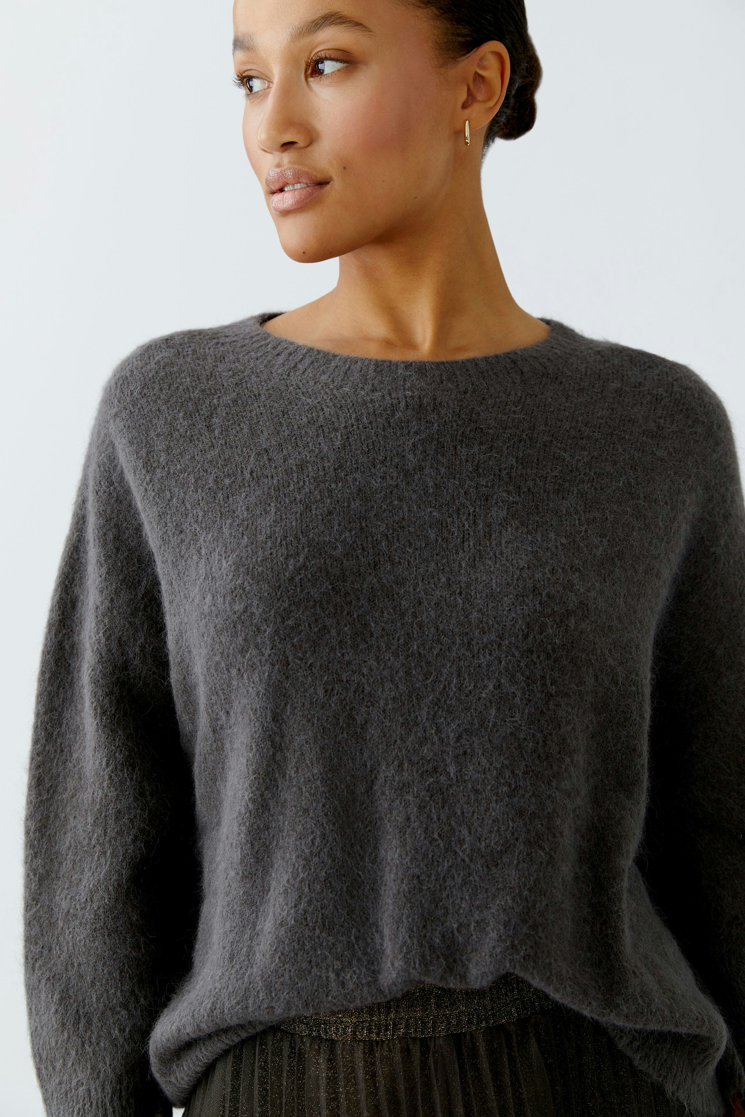 Casual women's pullover: A woman in a soft gray pullover with a relaxed fit and round neckline.