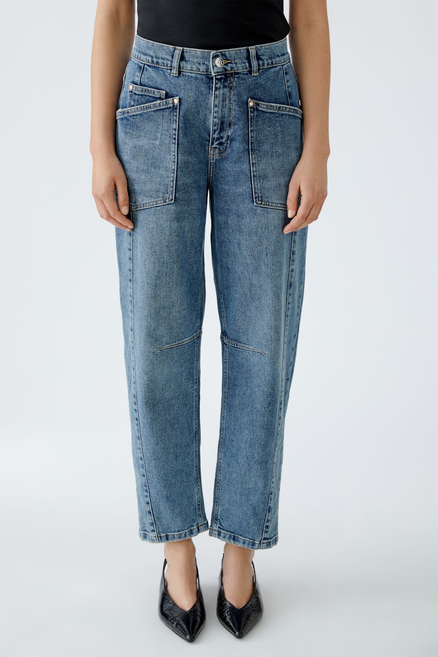 Bequeme Jeans Barrel: Frau trägt lässige, hellblaue Jeans mit großen Taschen und schmalem Bein.
