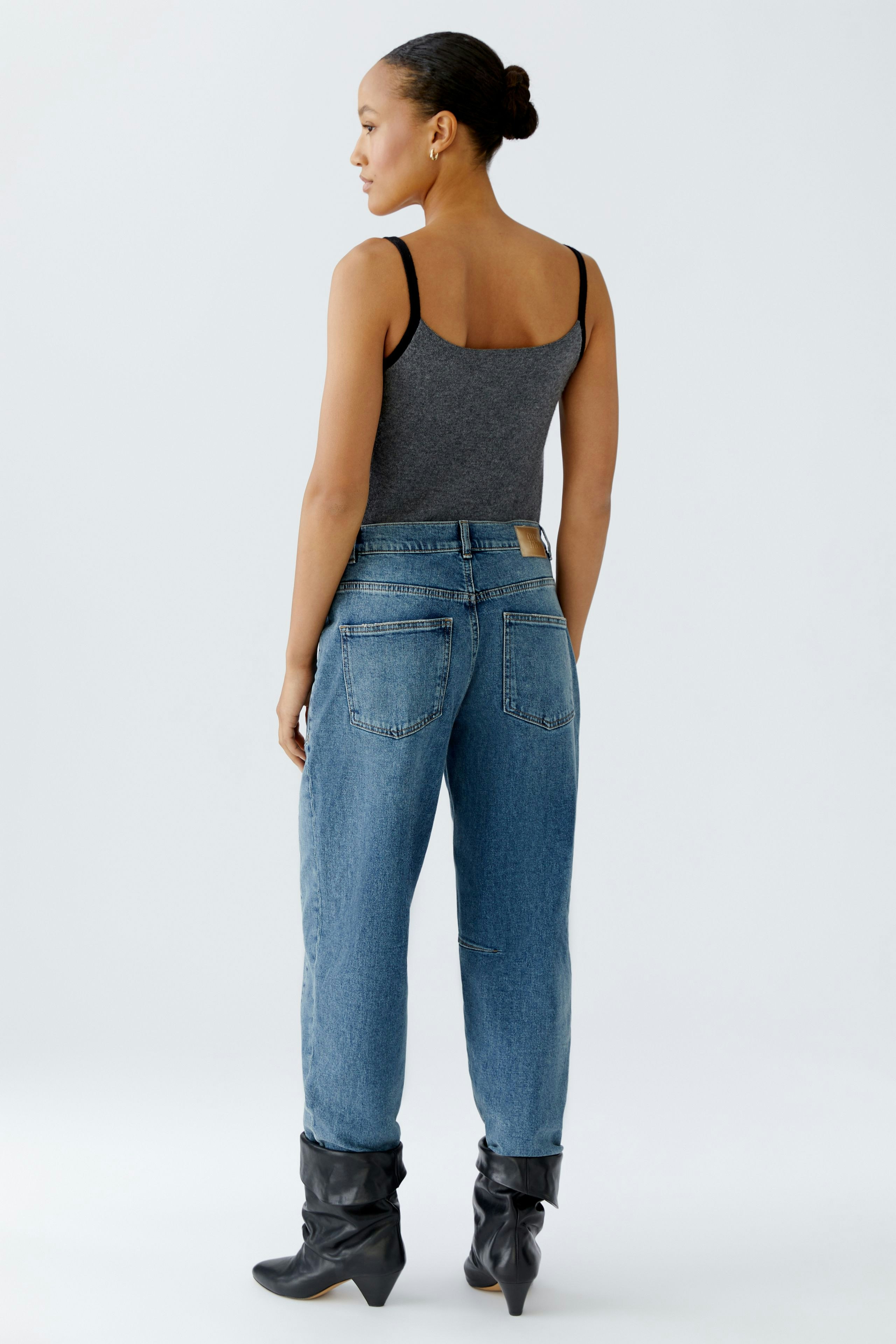 Casual women's jeans: A woman in blue barrel jeans with a relaxed fit, showcasing a simple and stylish look.