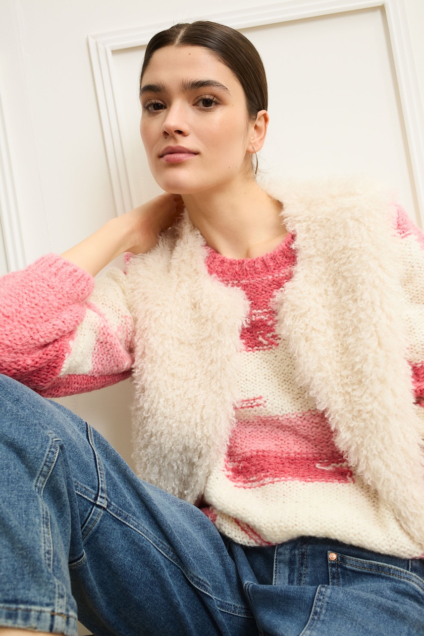 Casual women's jeans barrel: A woman in stylish jeans barrel paired with a fringed cardigan.