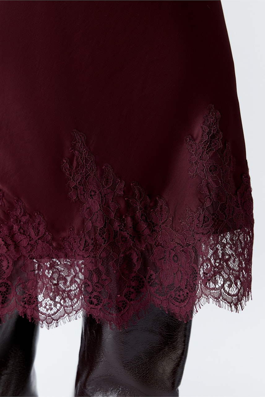 A-Linien-Rock in Bordeaux mit feiner Spitze am Saum, ideal für lässige Outfits.