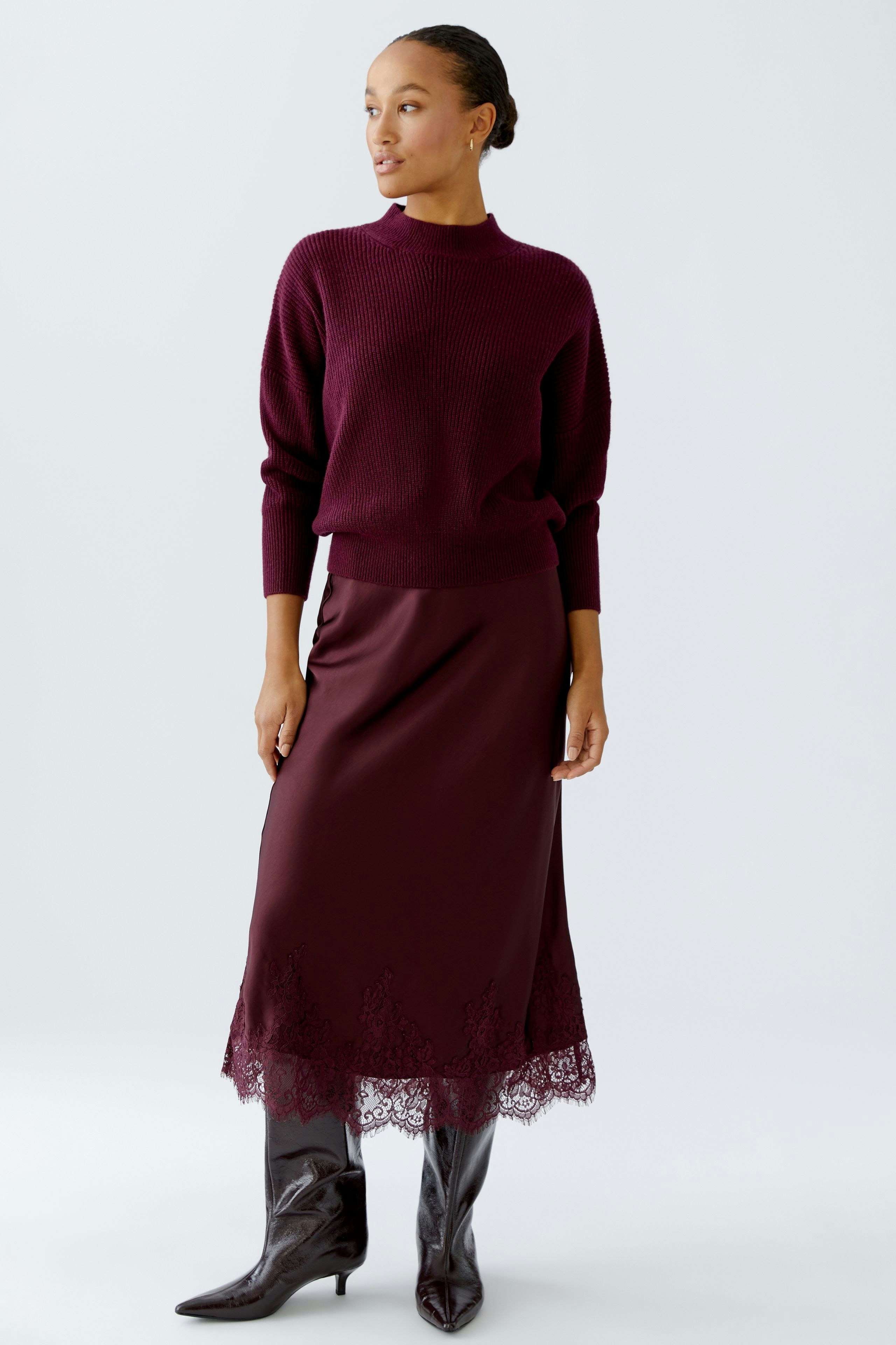 A-line skirt: Woman in a burgundy skirt with lace trim, paired with a matching pullover.