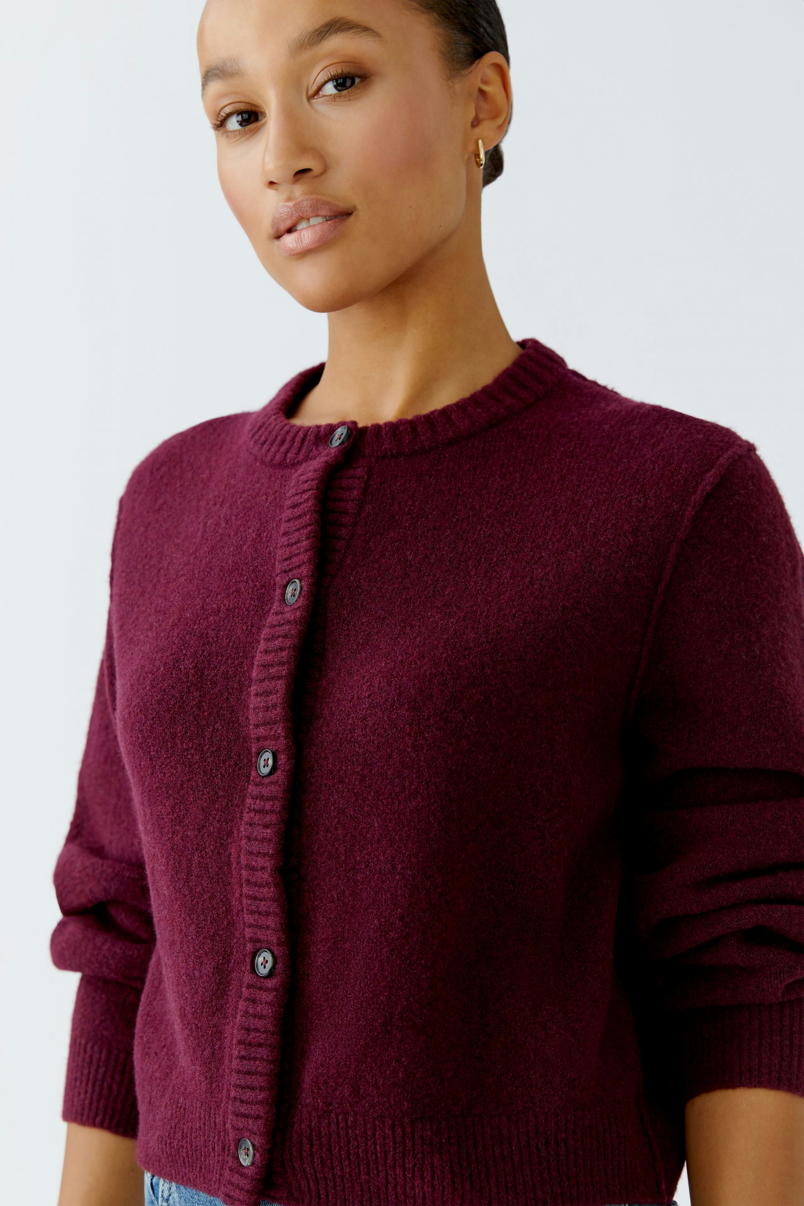 Casual women's cardigan: A woman in a burgundy cardigan with buttons, styled for a relaxed look.