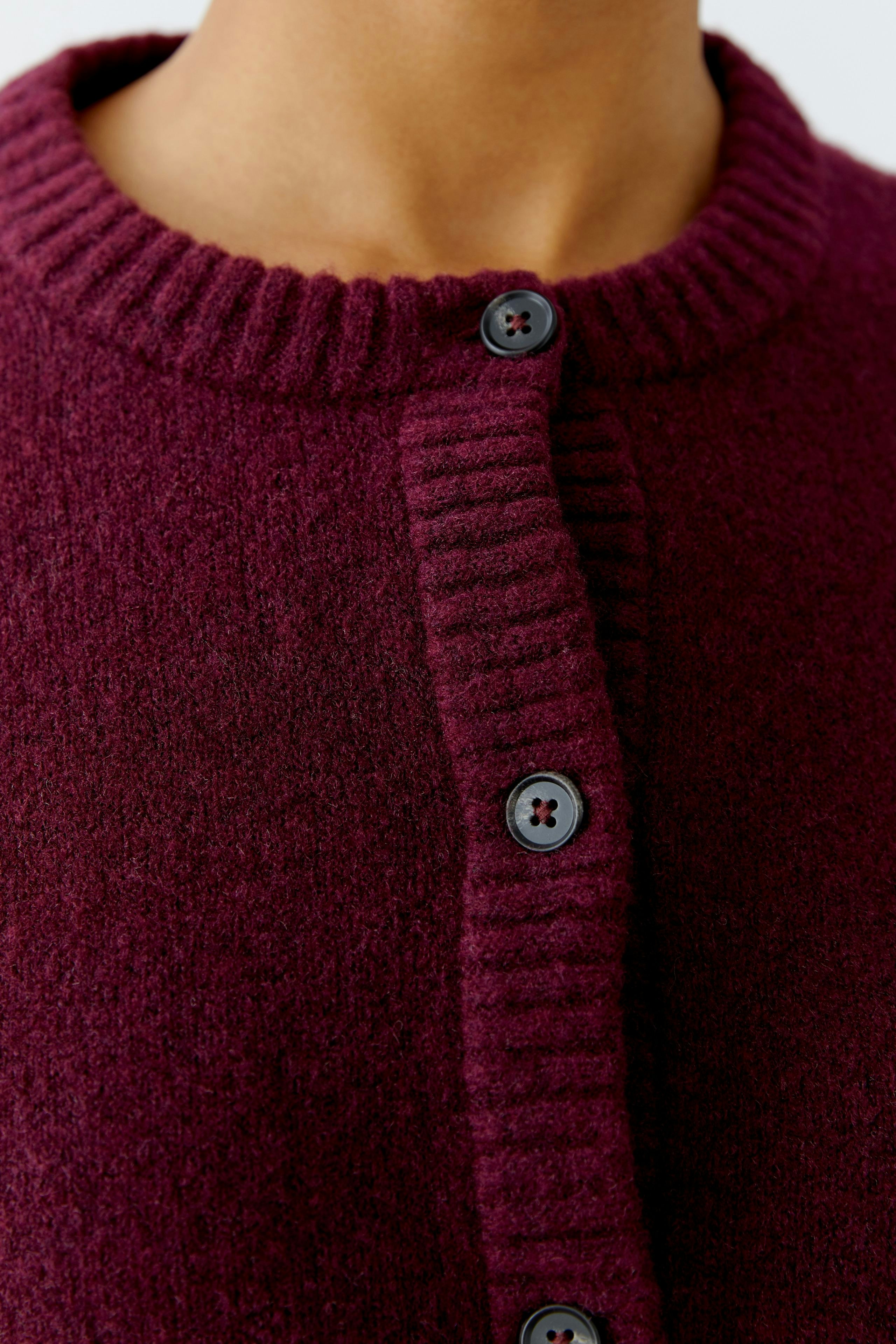 Cozy women's cardigan in deep burgundy with ribbed collar and button closure.
