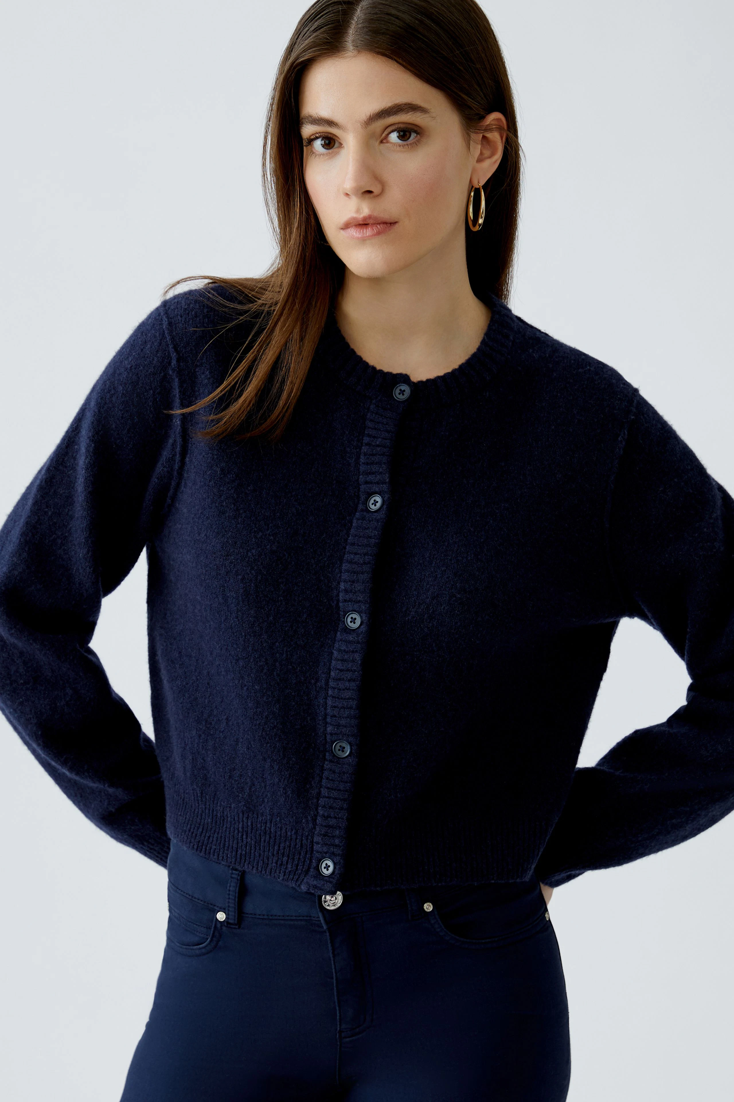 Dunkle Strickjacke: Frau trägt eine navyfarbene Strickjacke mit Knöpfen und lässigem Schnitt.