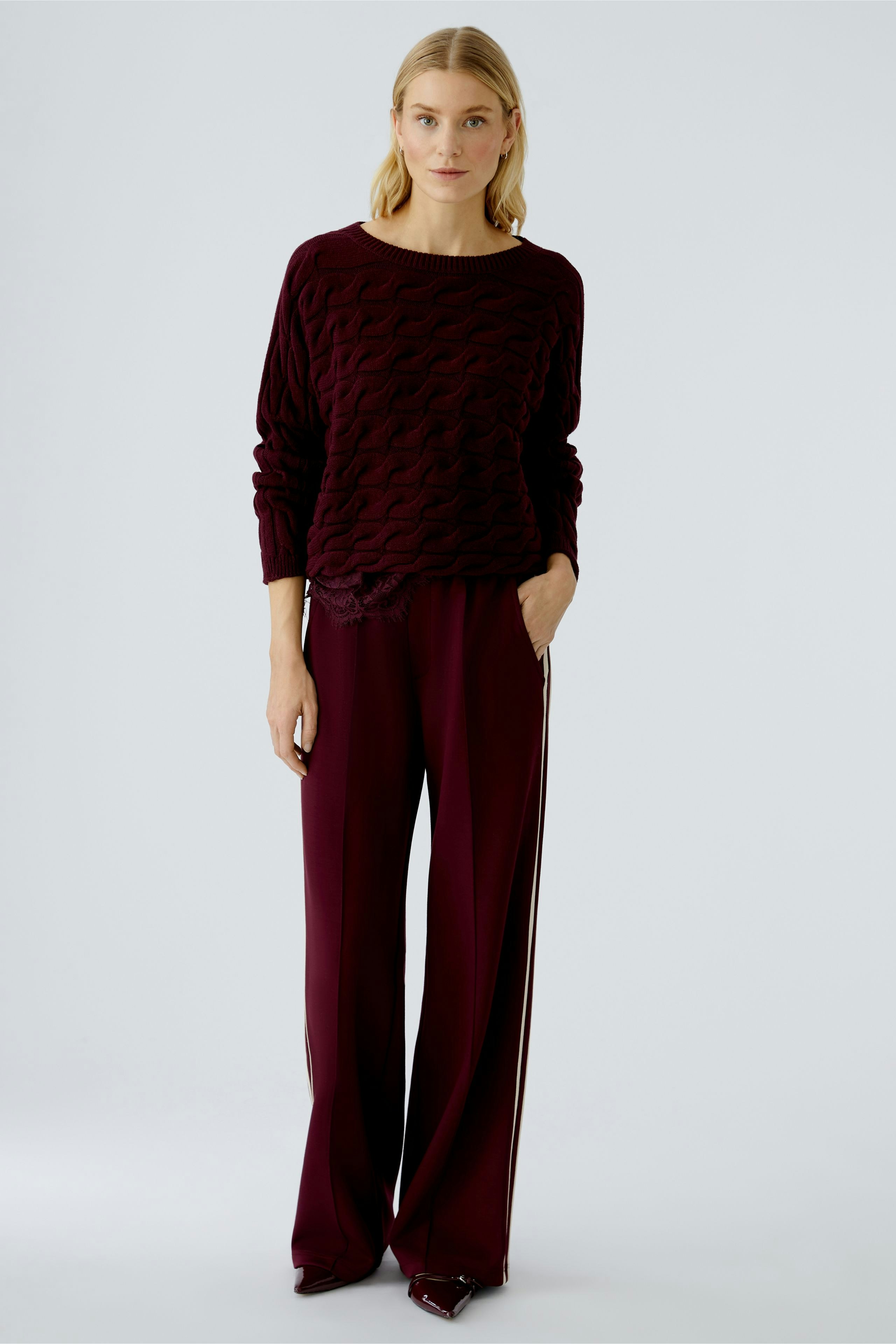 Casual women's pullover: A woman in a burgundy textured pullover paired with matching pants.