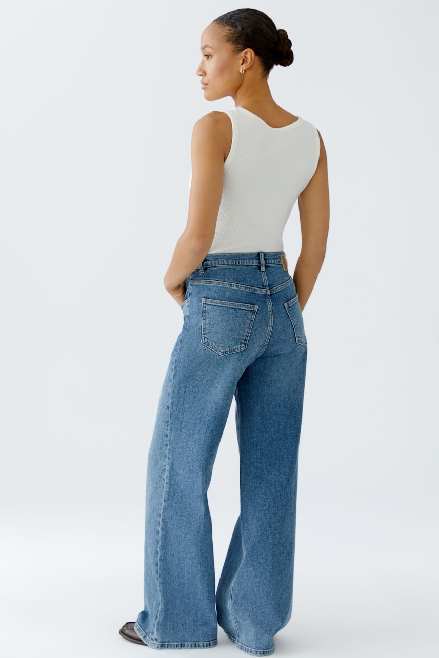 Bequeme 5-Pocket Hose: Frau in lässiger, weiter Jeans mit hohem Bund und klassischem Design.