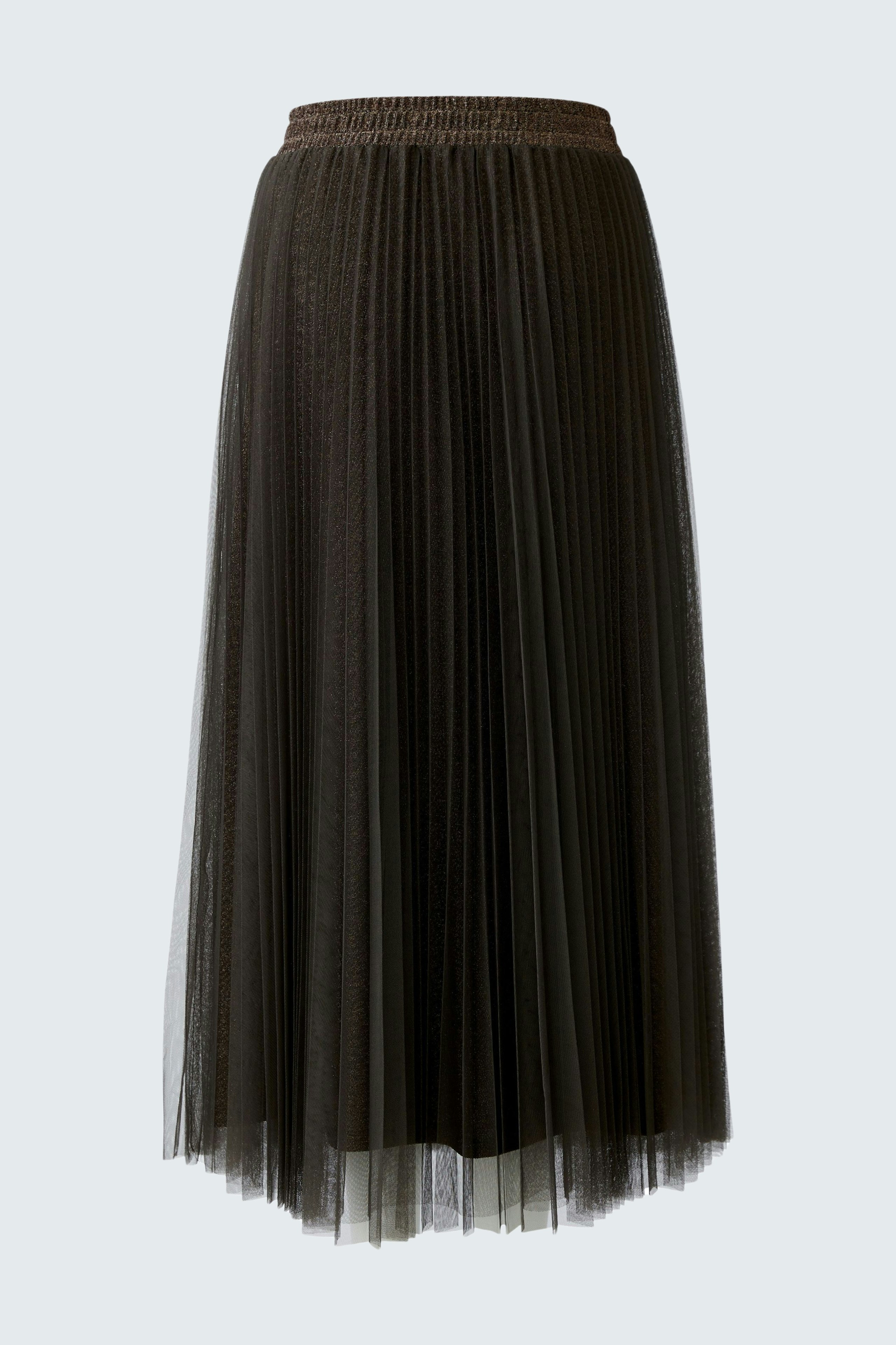 Flowy pleated skirt: A woman in a dark pleated skirt with an elastic waistband stands confidently.