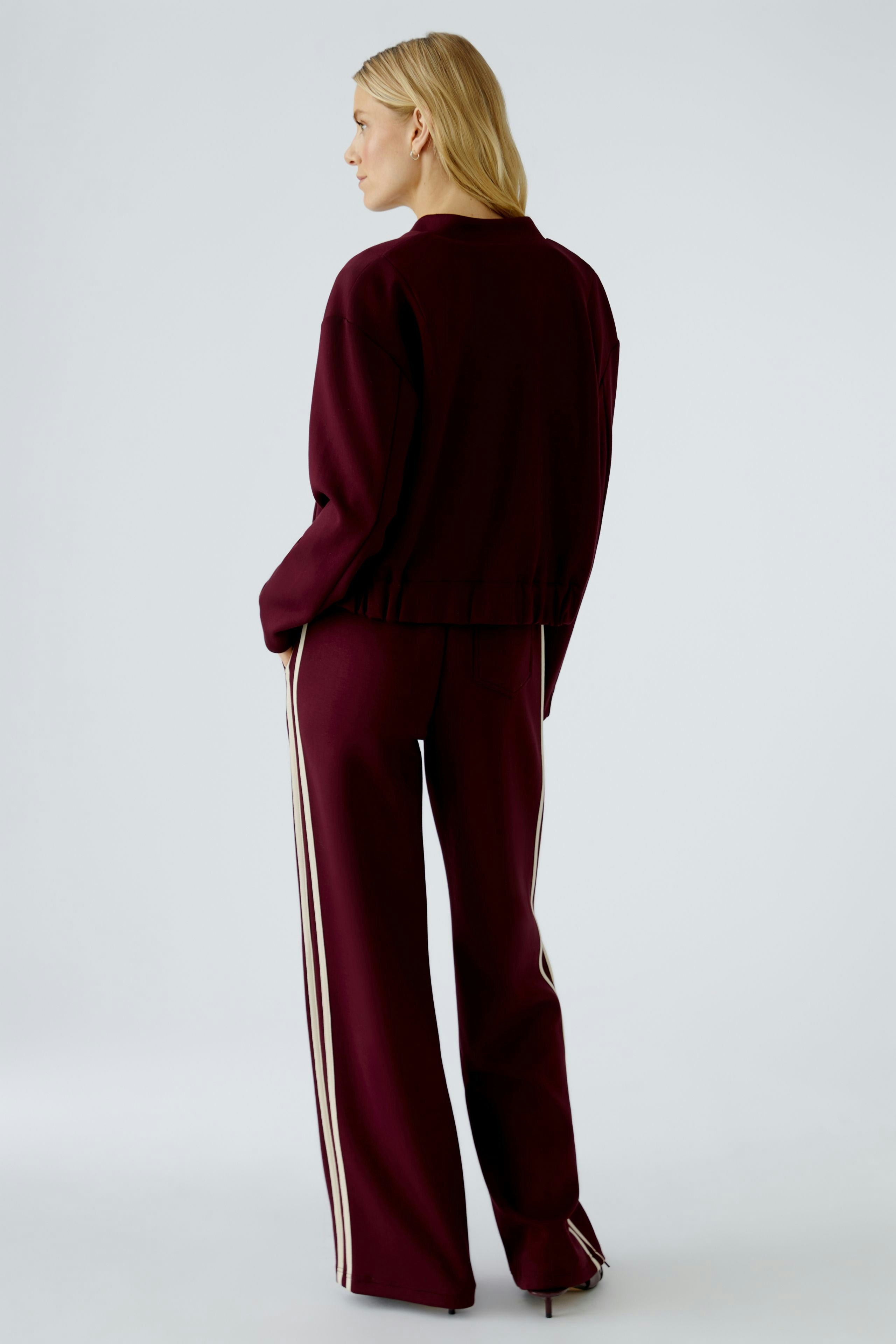 Casual women's blouson: A woman in a maroon oversized blouson with stylish side stripes.