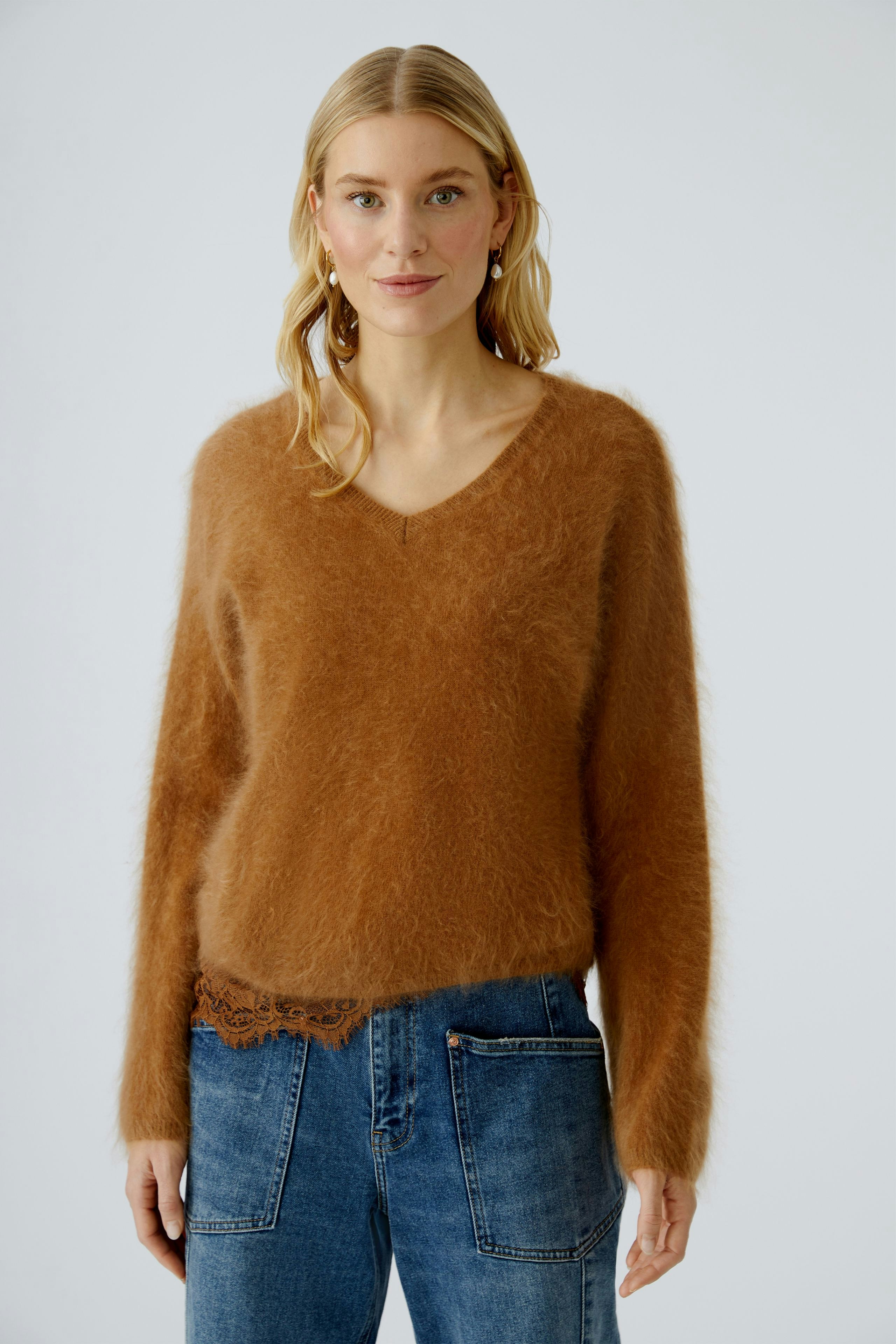 Casual women's pullover: A woman in a soft brown pullover with a V-neck and relaxed fit.