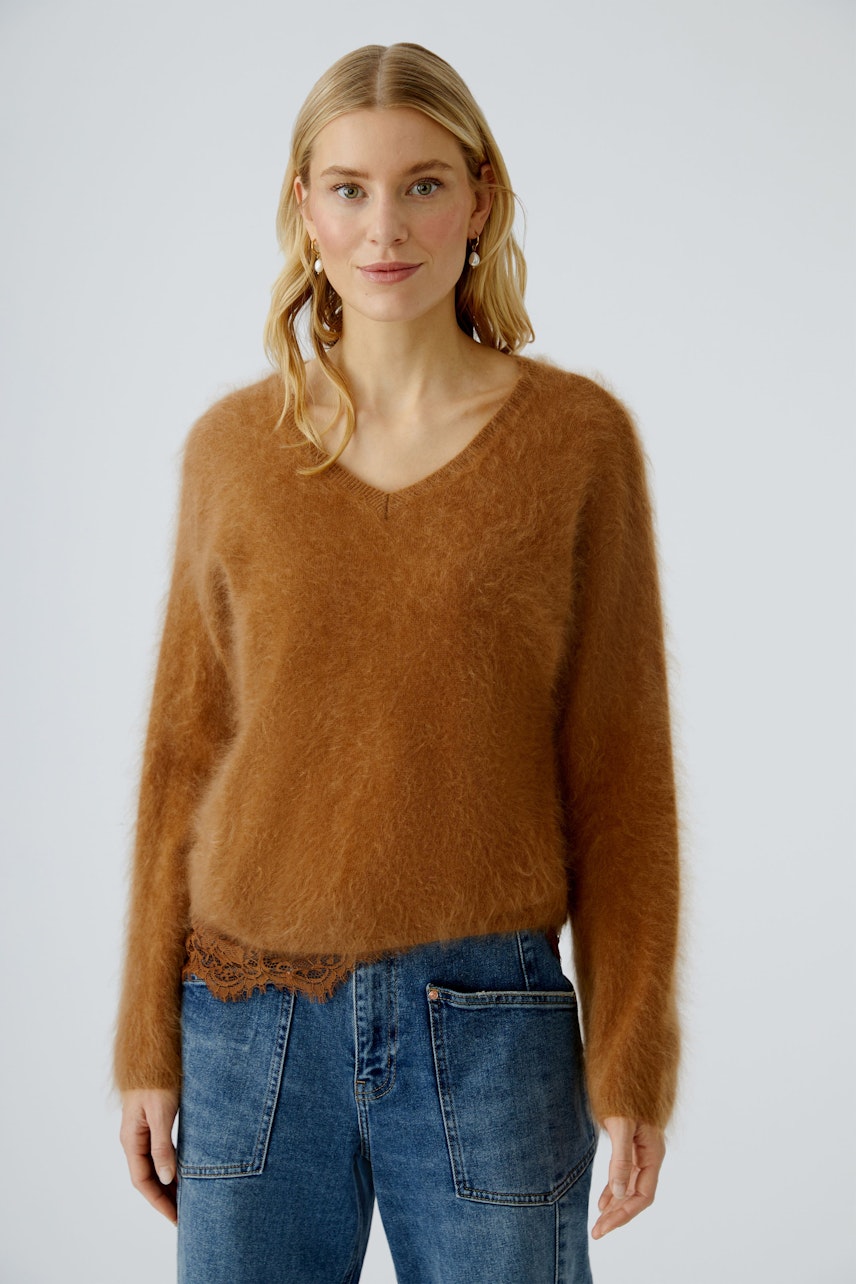 Casual women's pullover: A woman in a soft brown pullover with a V-neck and relaxed fit.