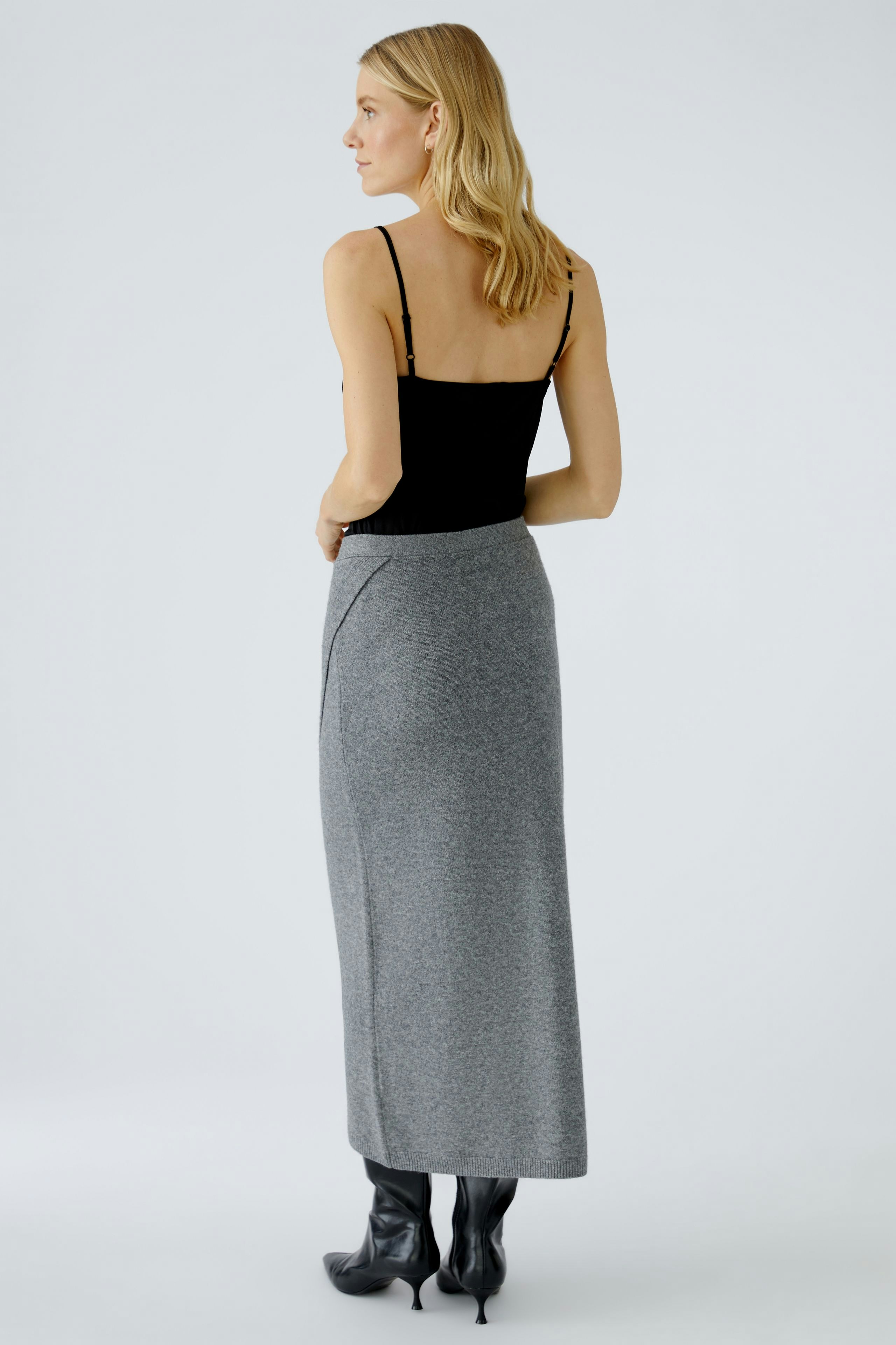 Casual women's knit skirt: A woman in a gray knit skirt with a sleek design, showcasing a modern look.