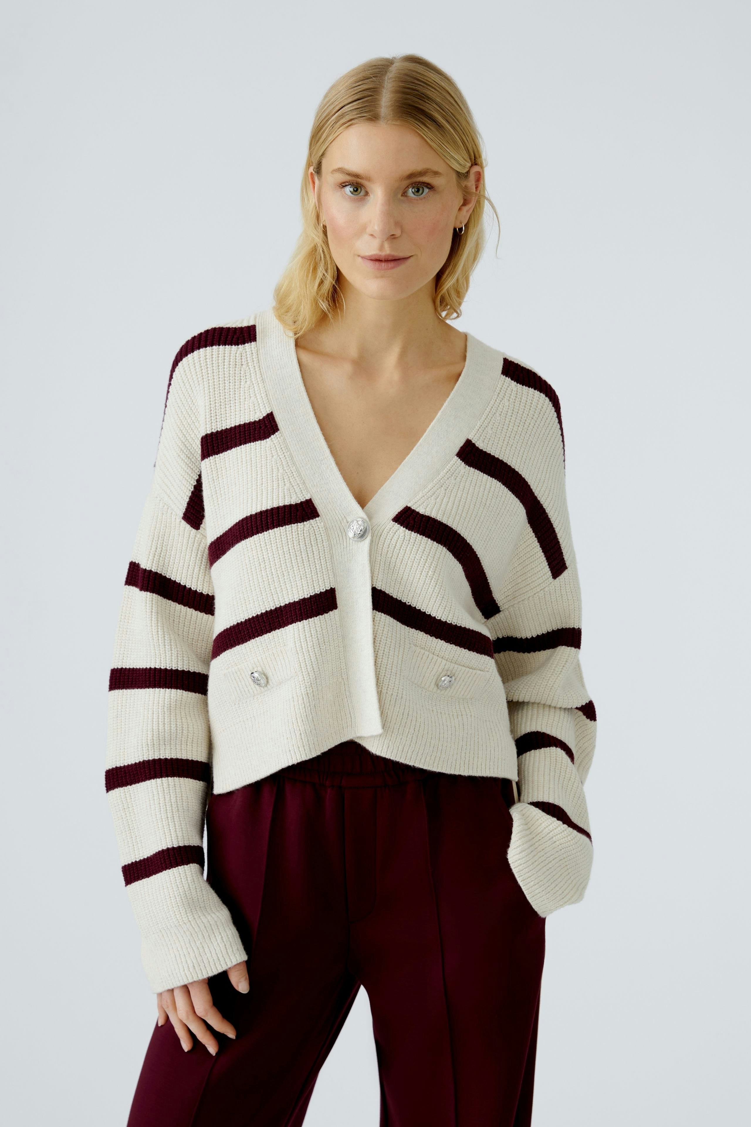Casual women's cardigan: Young woman in a striped, cropped cardigan with buttons and relaxed fit.
