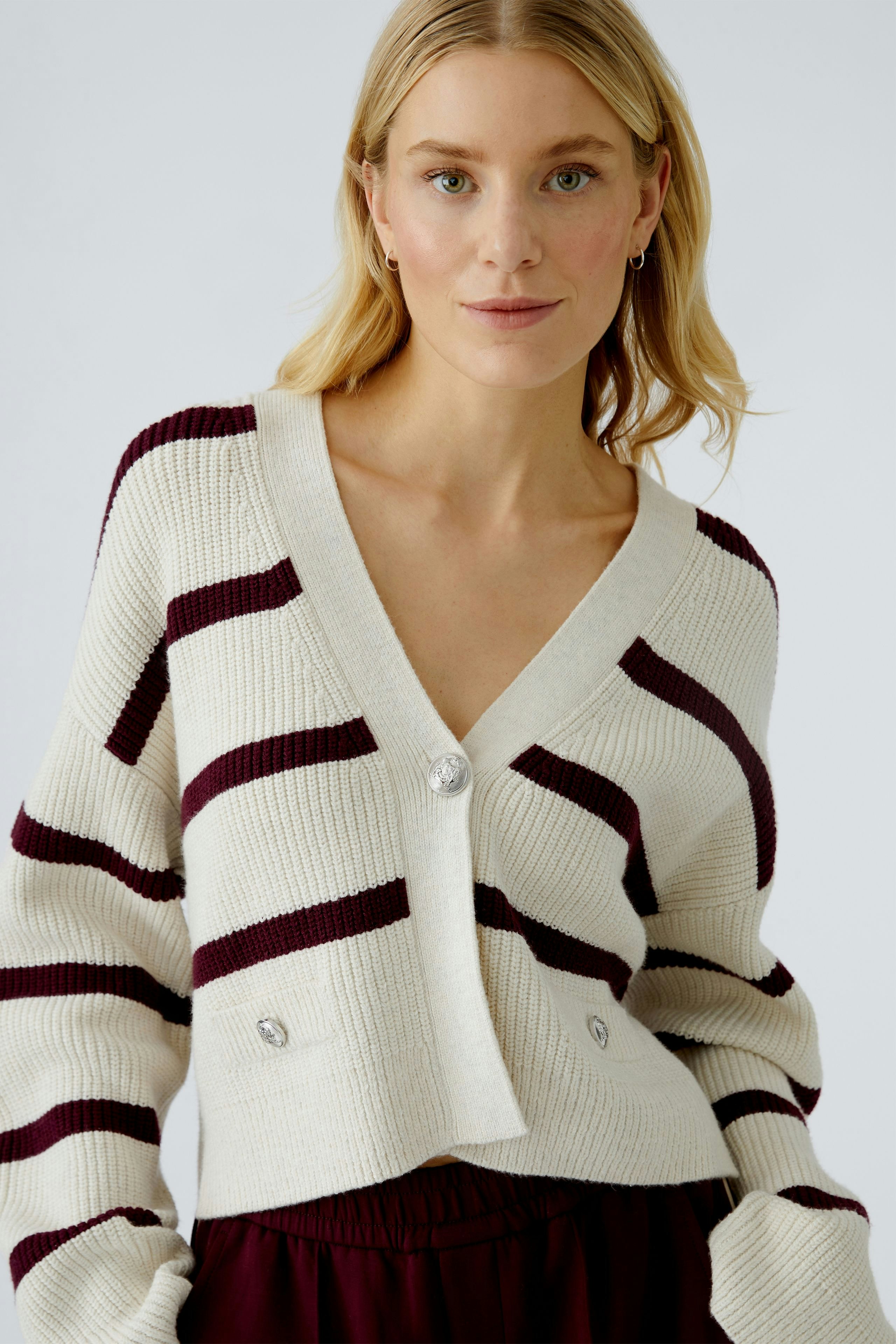 Casual women's cardigan: A woman in a striped, cropped cardigan with buttons, styled effortlessly.