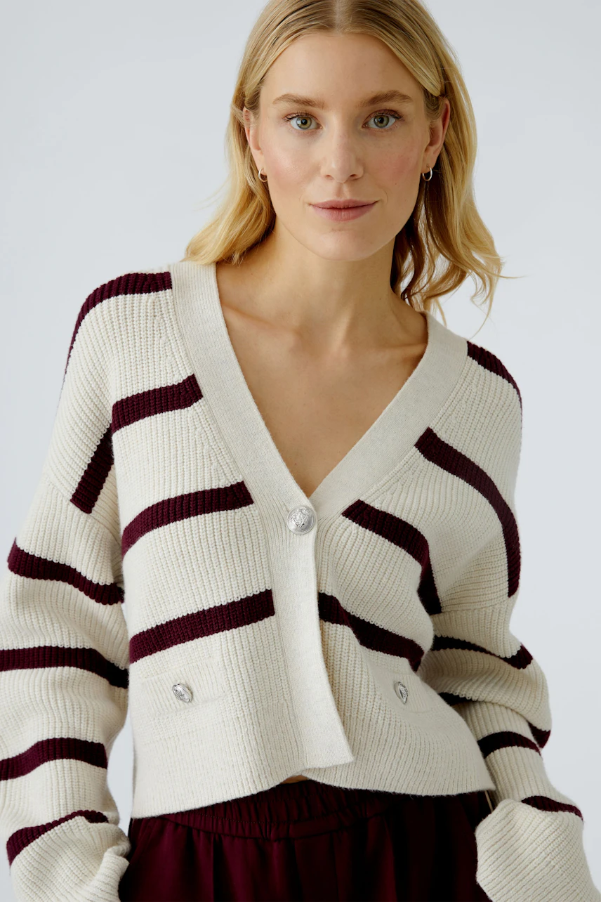 Damen-Strickjacke: Frau in gestreifter, kurzer Strickjacke mit Knöpfen und V-Ausschnitt.