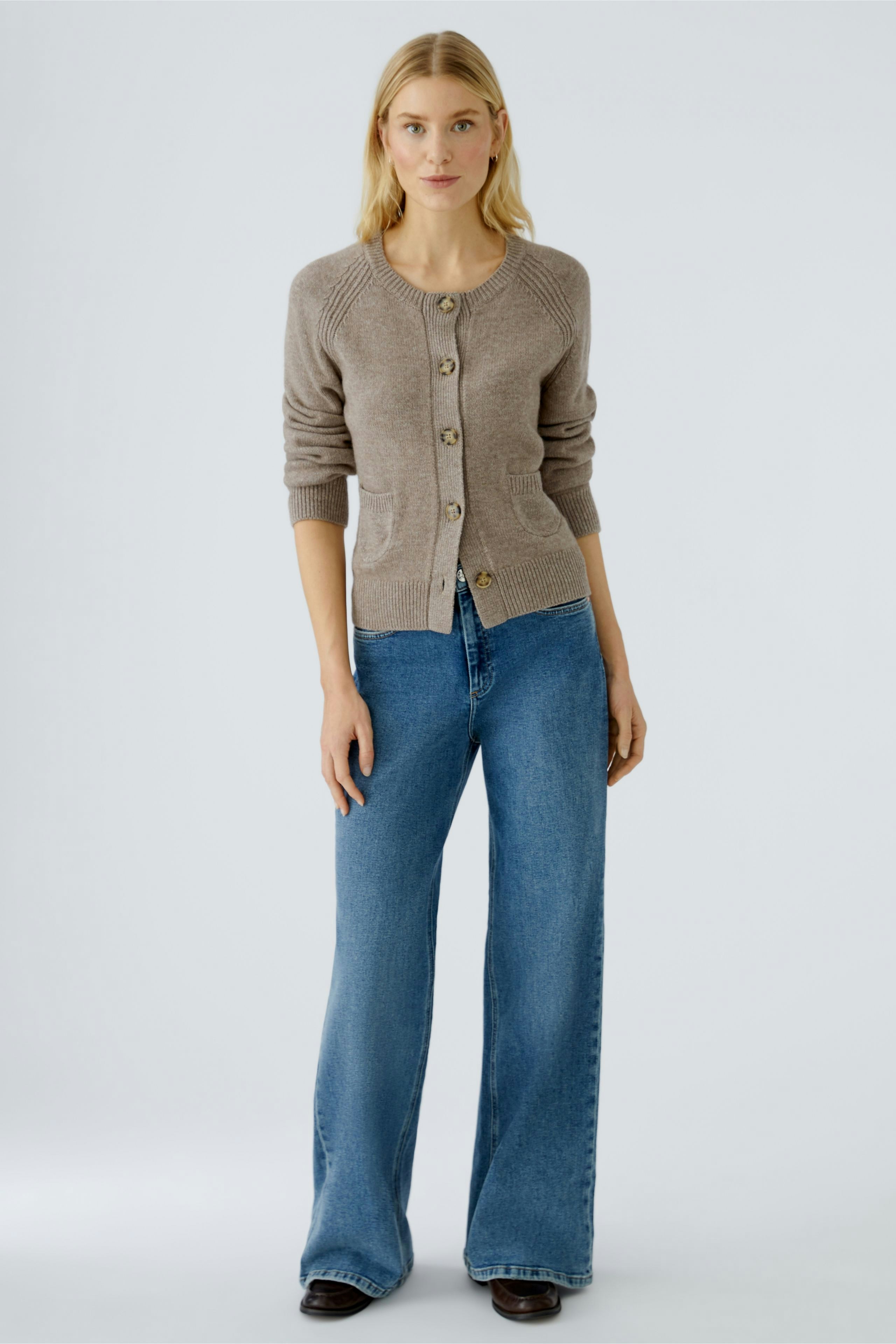 Casual women's cardigan: A woman in a light brown cardigan with buttons, paired with wide-leg jeans.