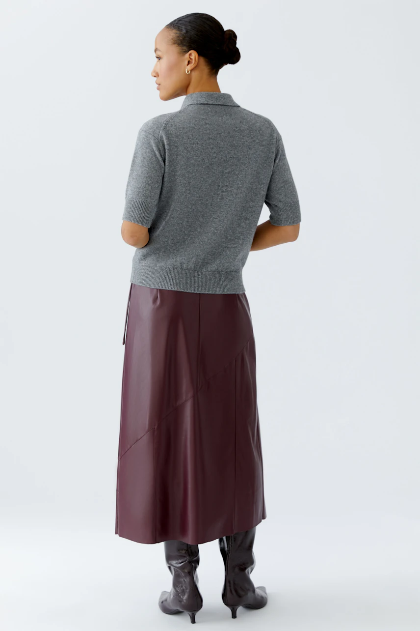 Casual women's pullover: A woman in a gray short-sleeve pullover paired with a burgundy skirt.