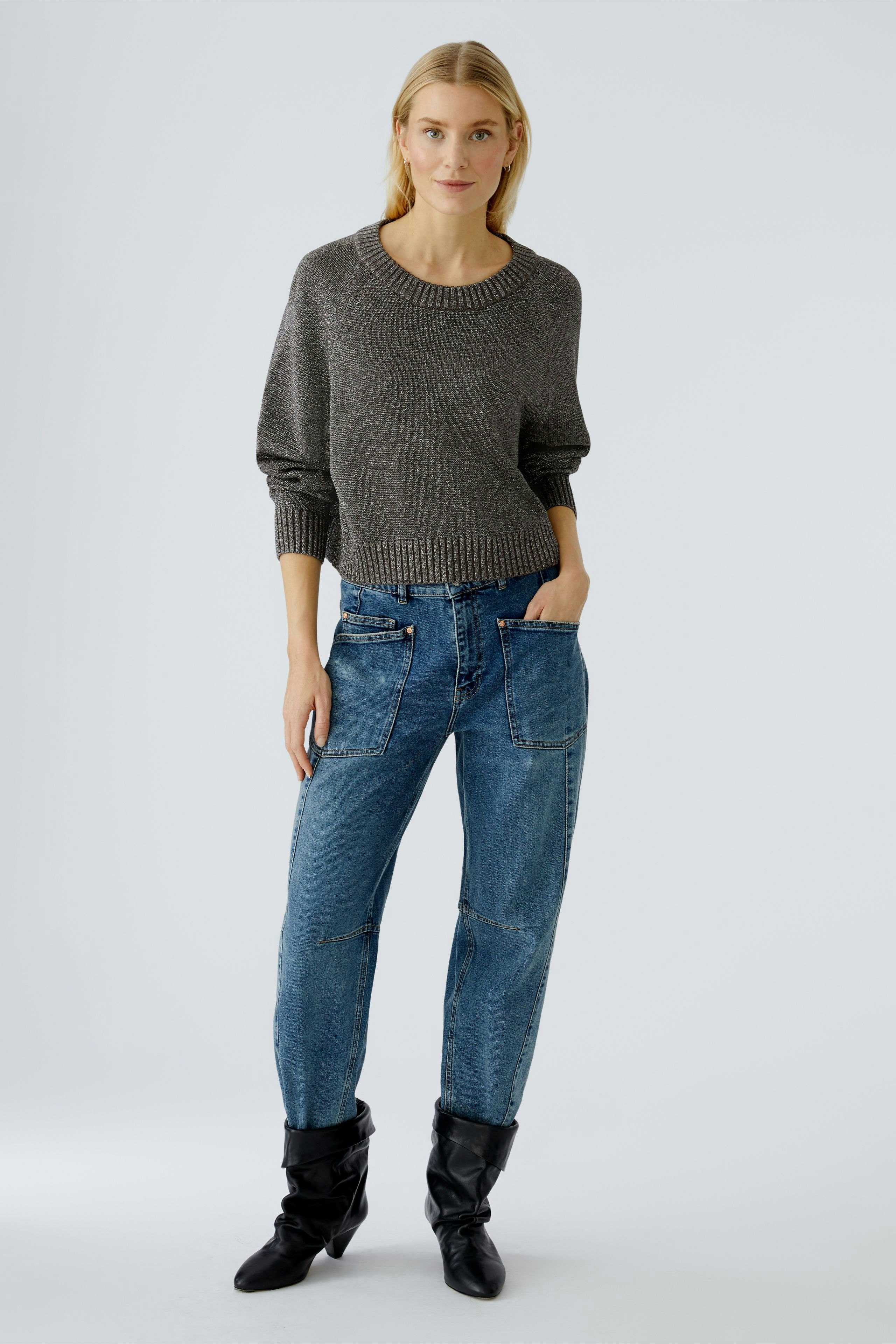 Casual women's pullover: A woman in a gray knit pullover paired with relaxed-fit jeans.