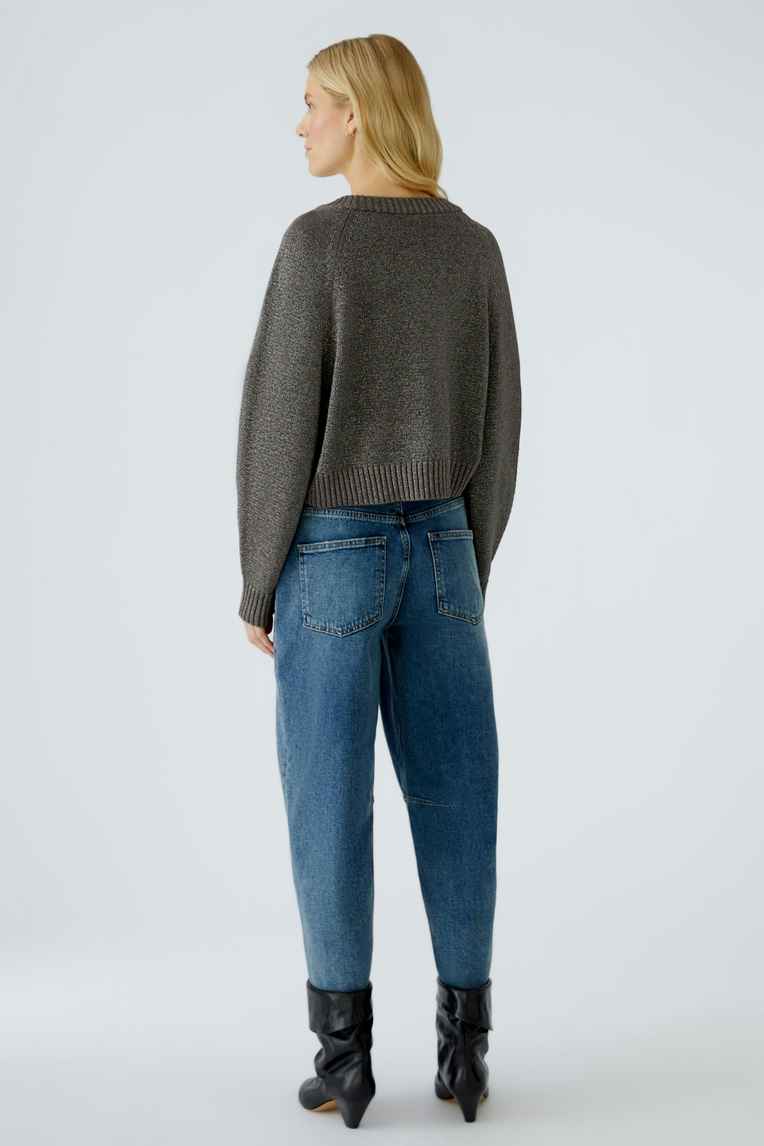 Casual women's pullover: A woman in a cropped gray pullover paired with relaxed-fit jeans.