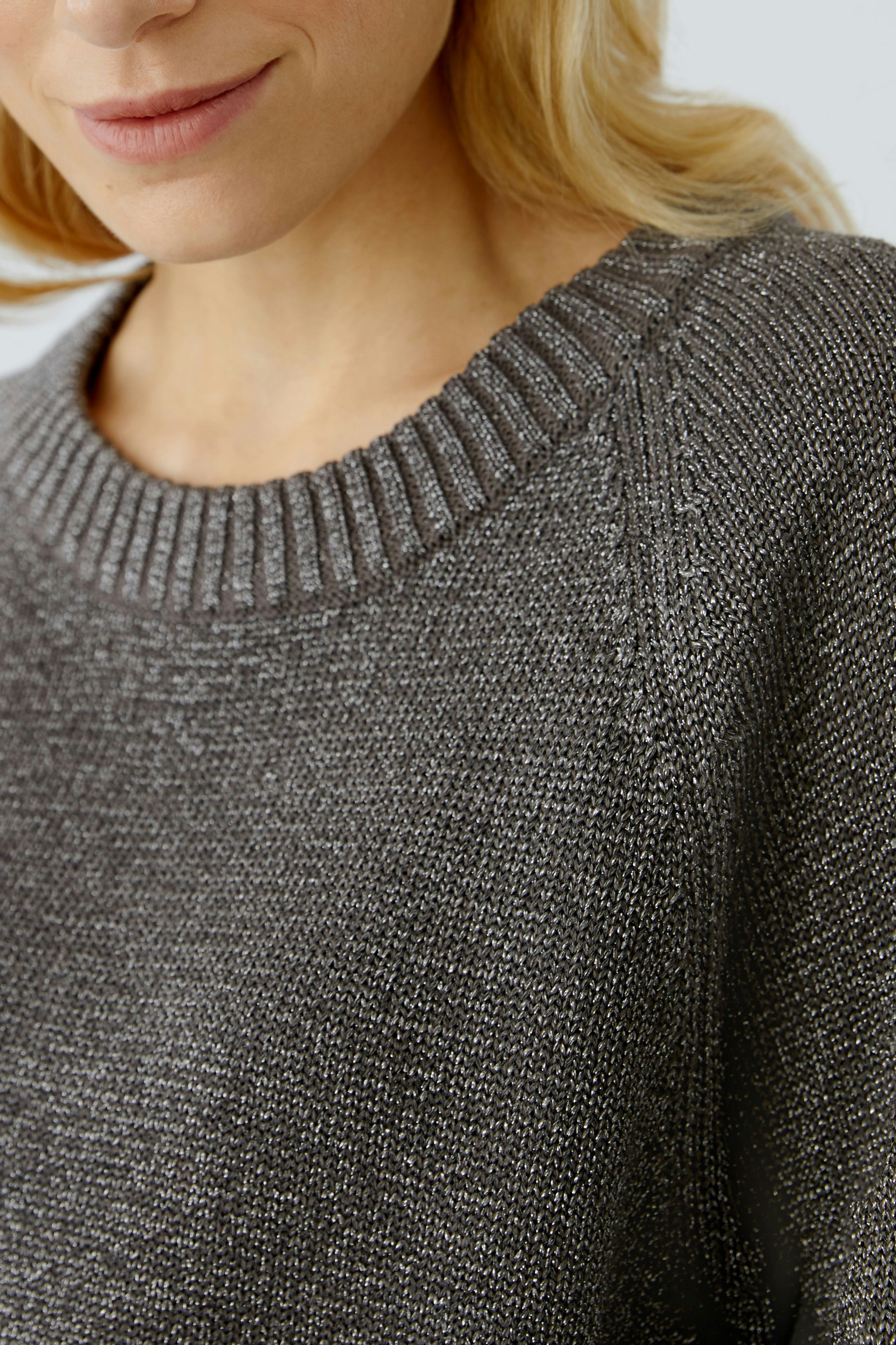 Casual women's pullover: Close-up of a woman in a cozy gray pullover with a ribbed neckline.