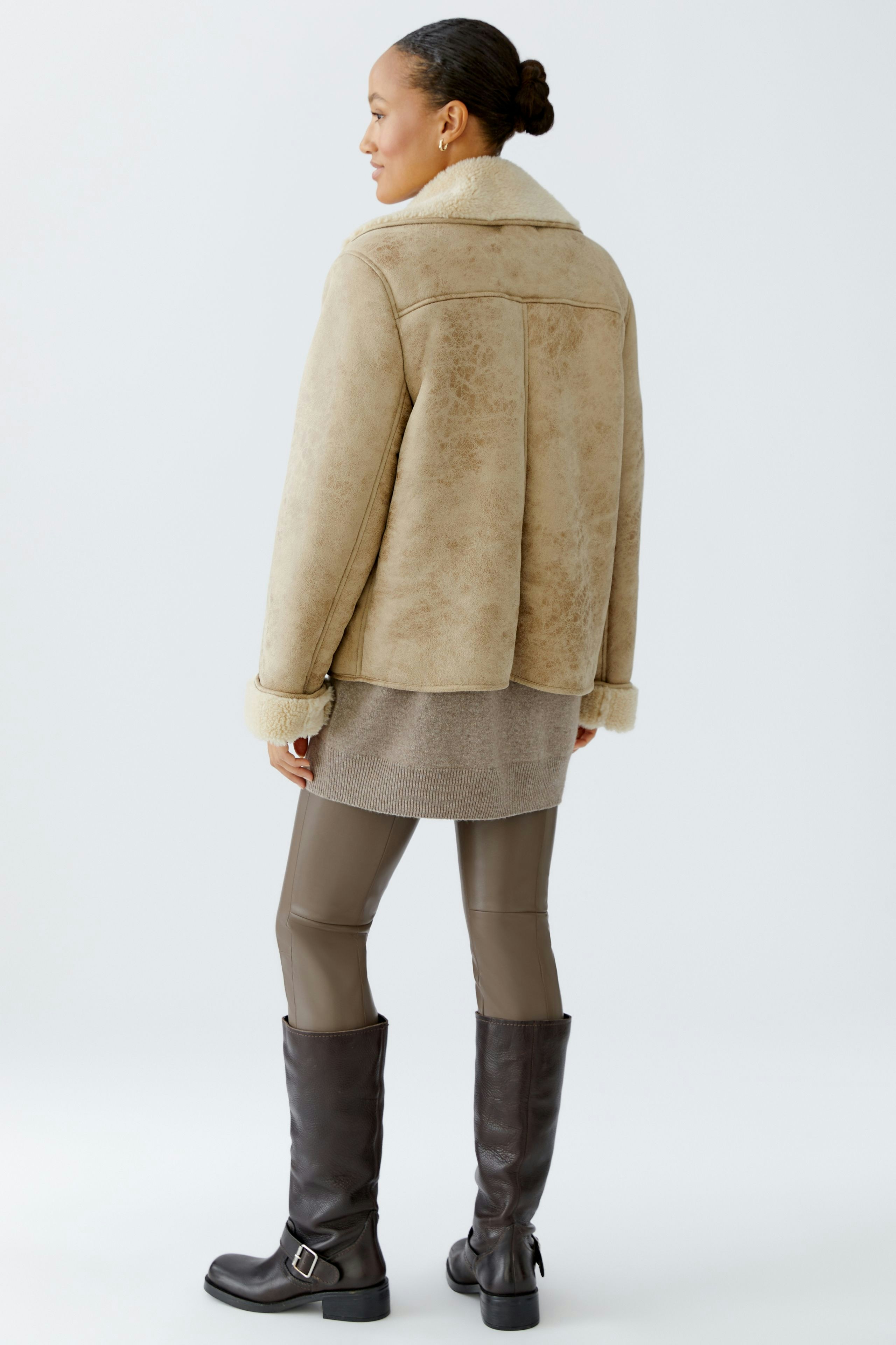 Casual women's outdoor jacket: A woman in a beige jacket with a soft collar, paired with stylish leggings.