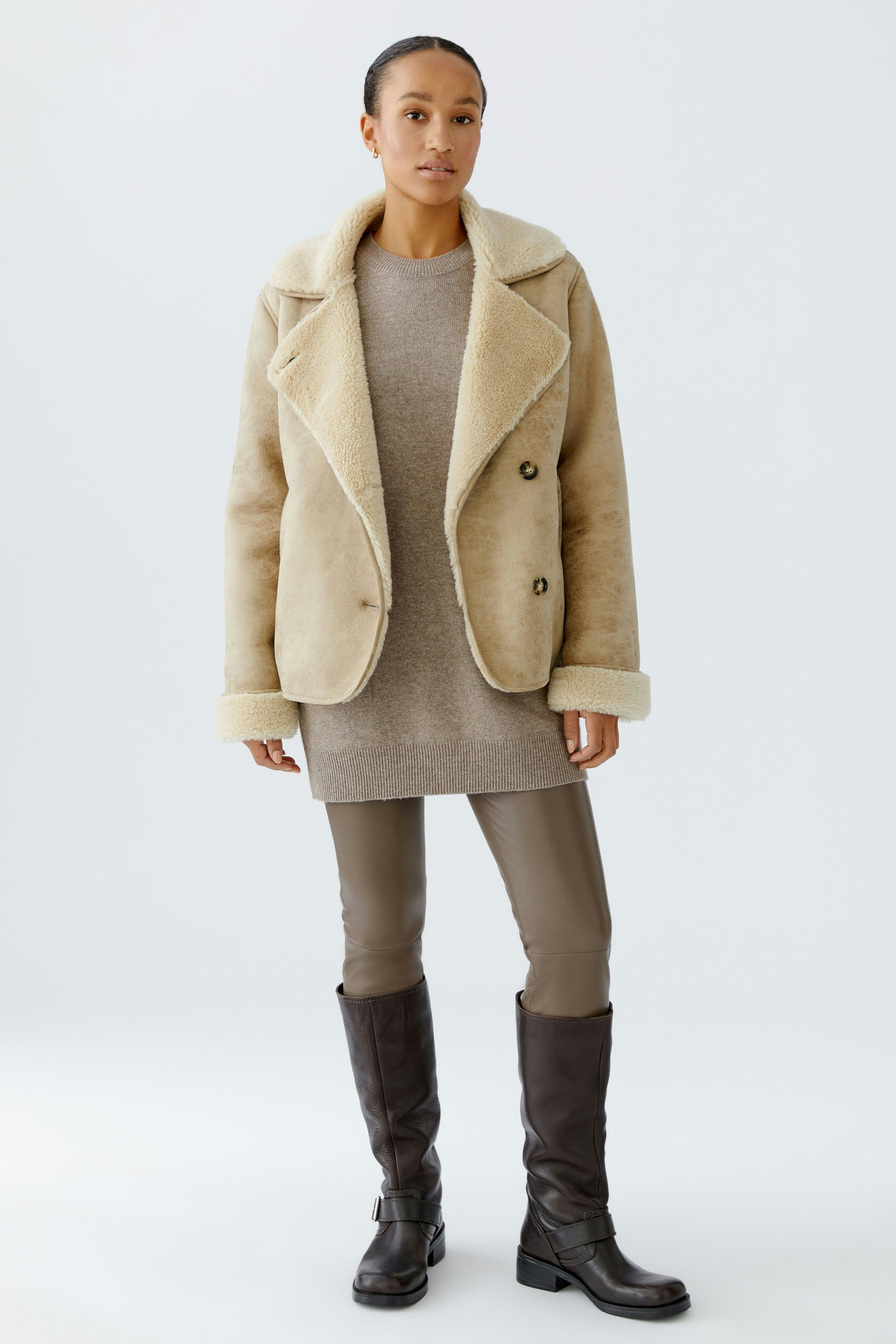 Casual women's outdoor jacket: A woman in a beige jacket with a soft collar, paired with a simple dress.