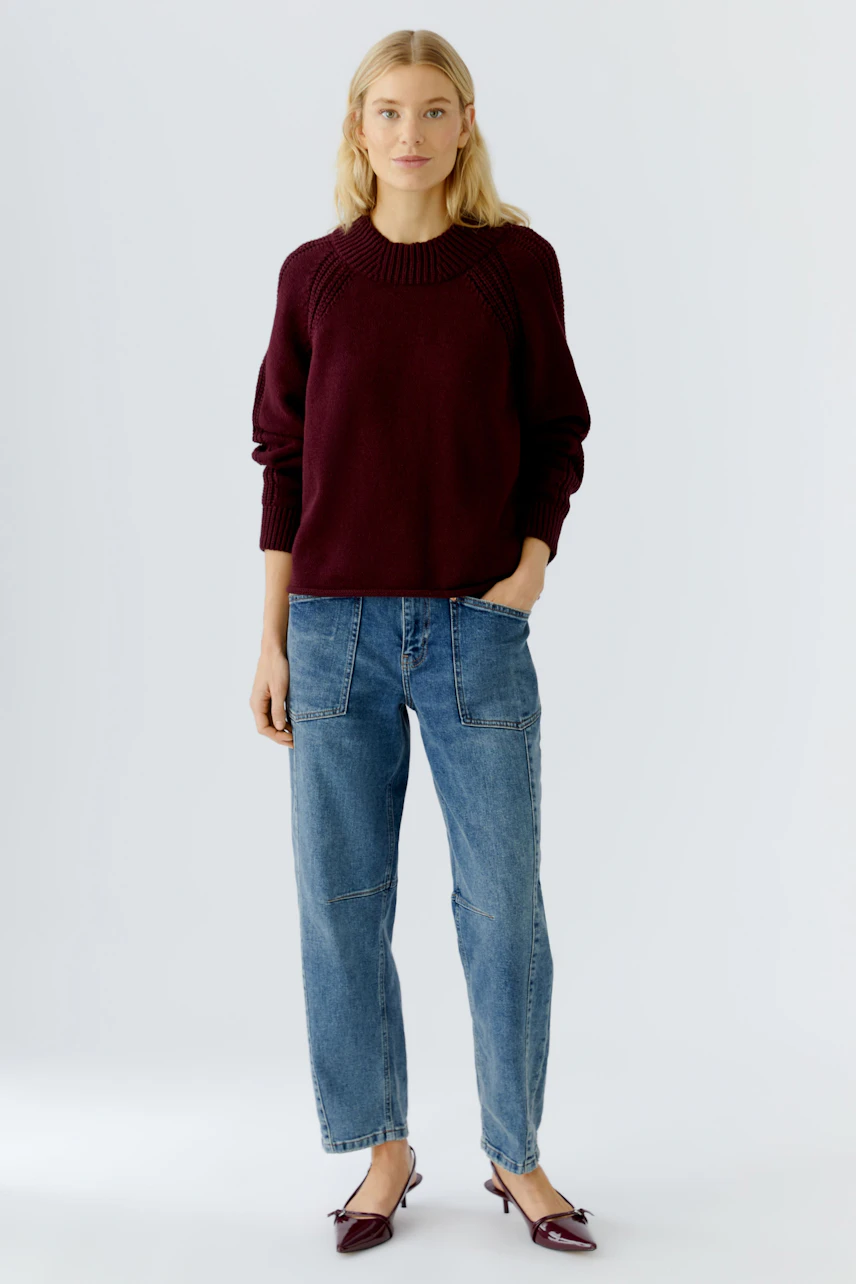 Damen-Pullover in dunklem Rot: Junge Frau trägt einen lässigen Strickpullover mit Rundhalsausschnitt.