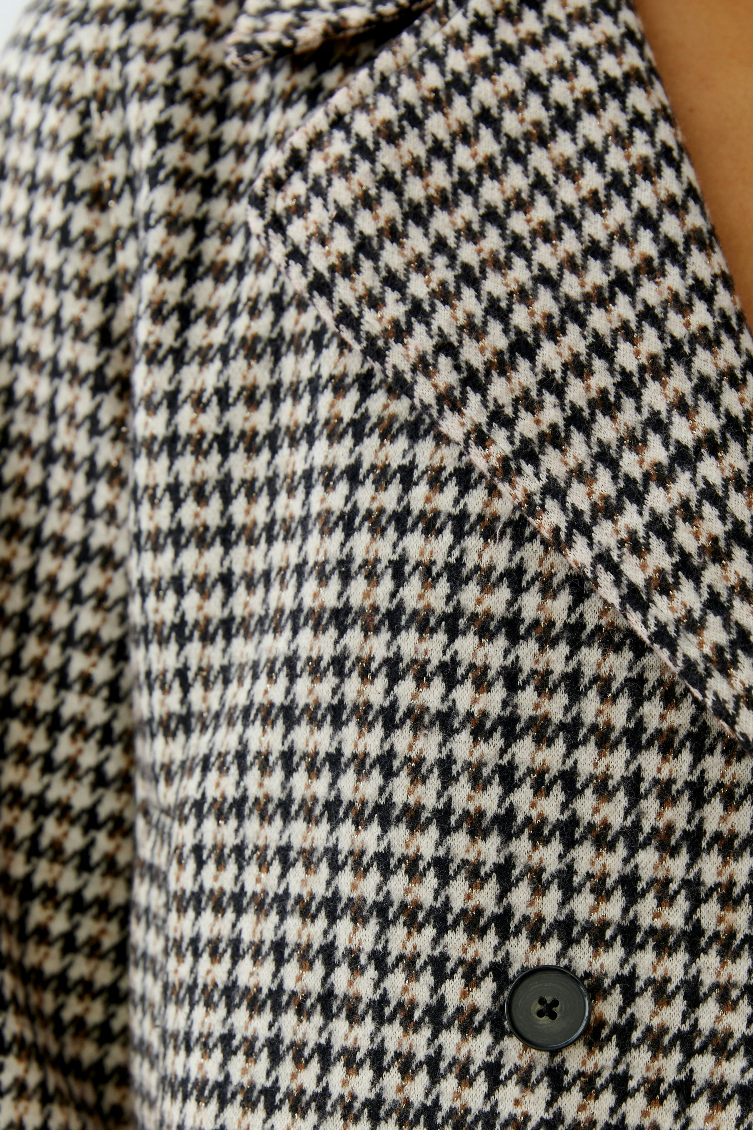 Stylish women's jacket with a houndstooth pattern and classic lapels, perfect for casual wear.