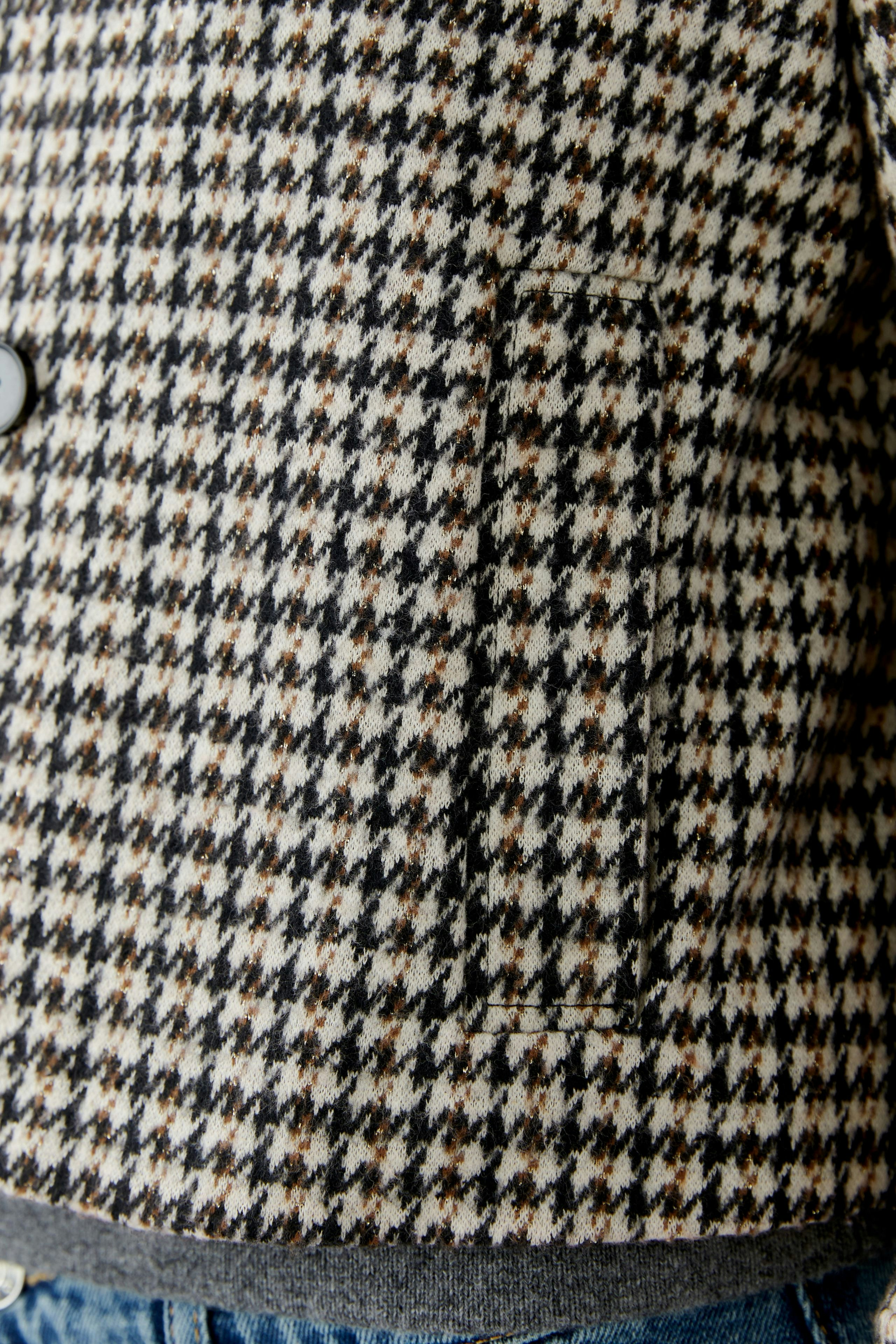 Stylish women's jacket in a classic houndstooth pattern, featuring a comfortable fit and practical pockets.