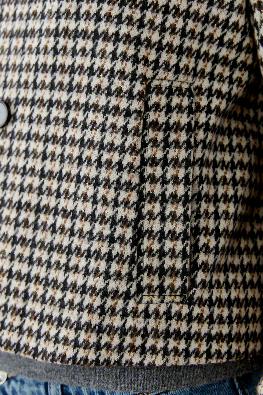 Stylish women's jacket in a classic houndstooth pattern, featuring a comfortable fit and practical pockets.