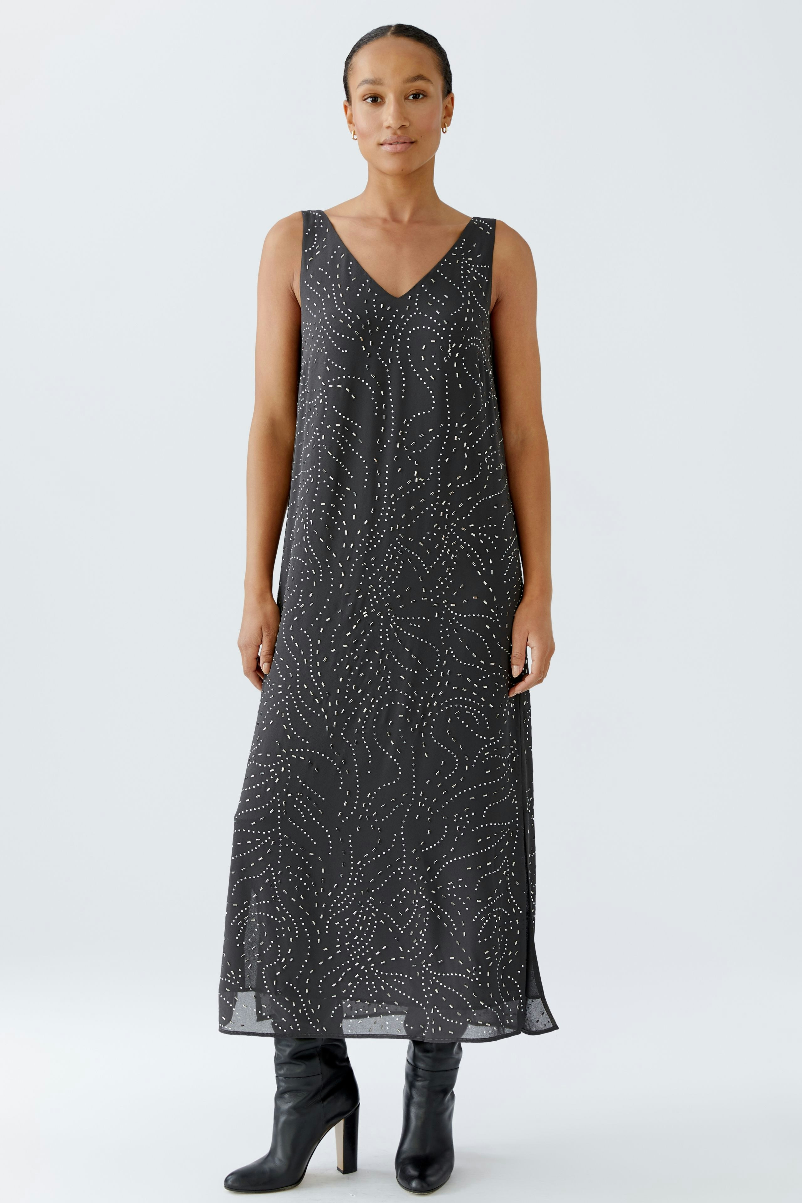 Casual women's dress: A woman in a long, patterned dress with a V-neckline and stylish boots.