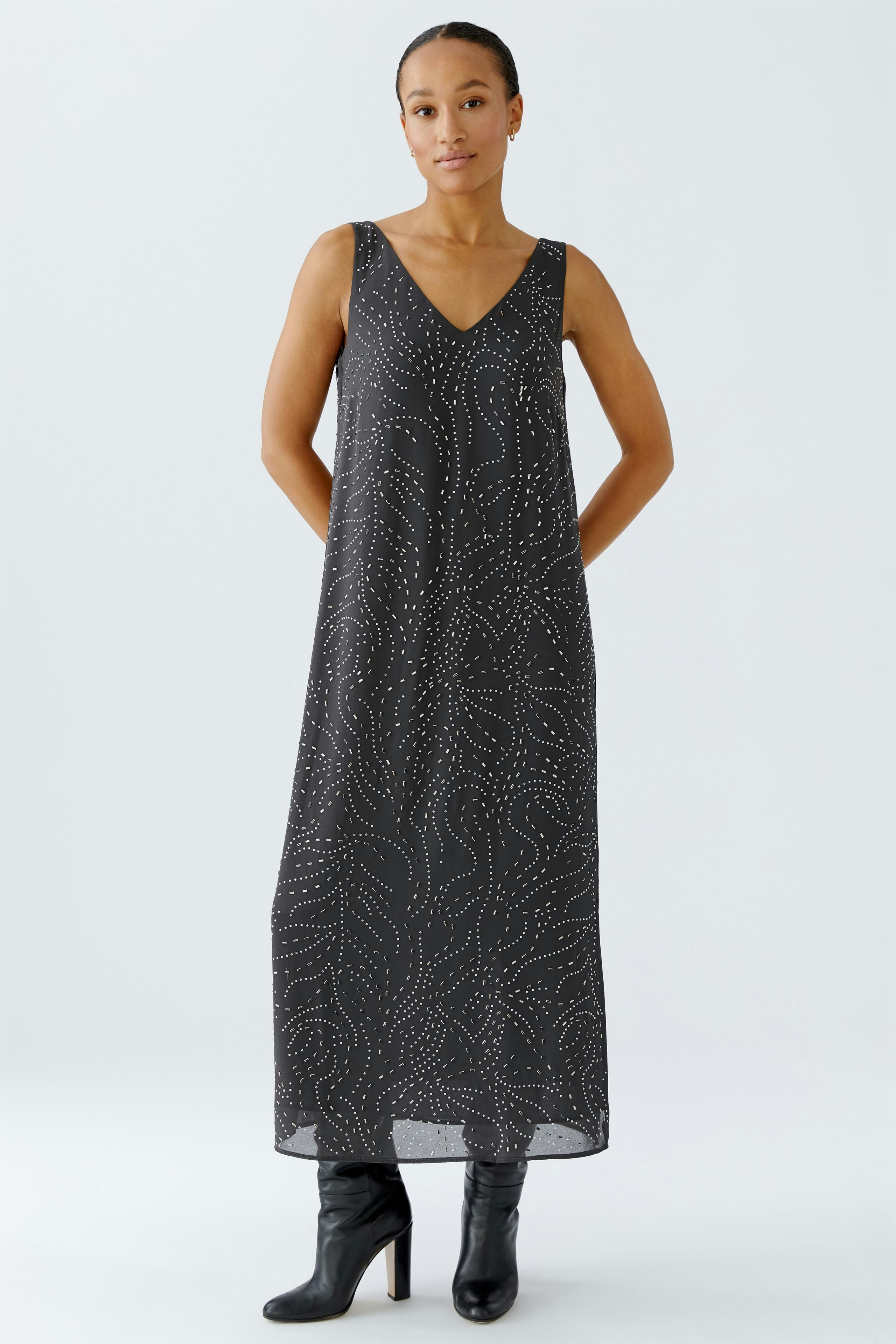 Casual women's dress: A woman in a long, patterned dress with a V-neckline stands confidently.