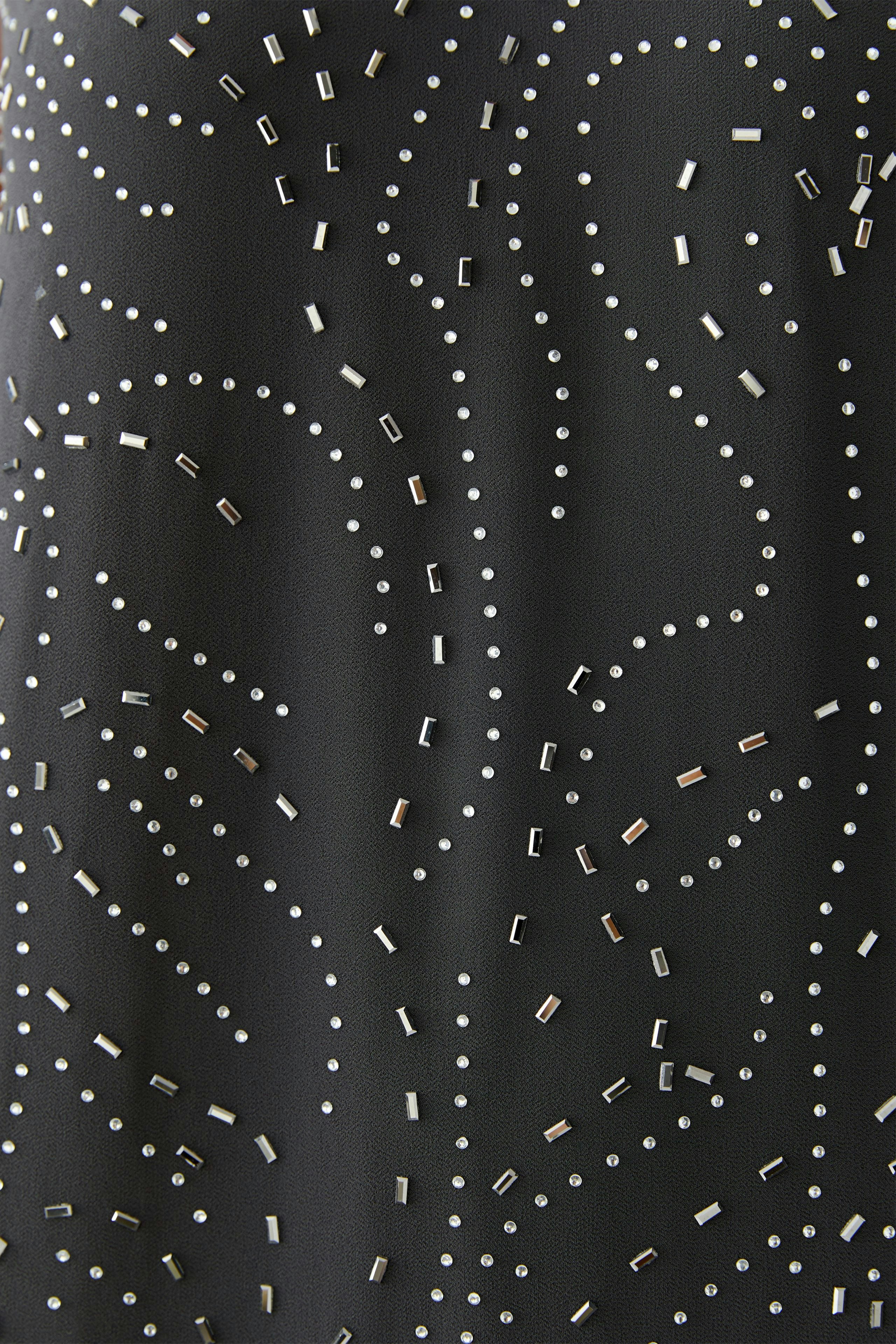 Stylish women's dress with decorative sequins, showcasing a flowing design and modern patterns.