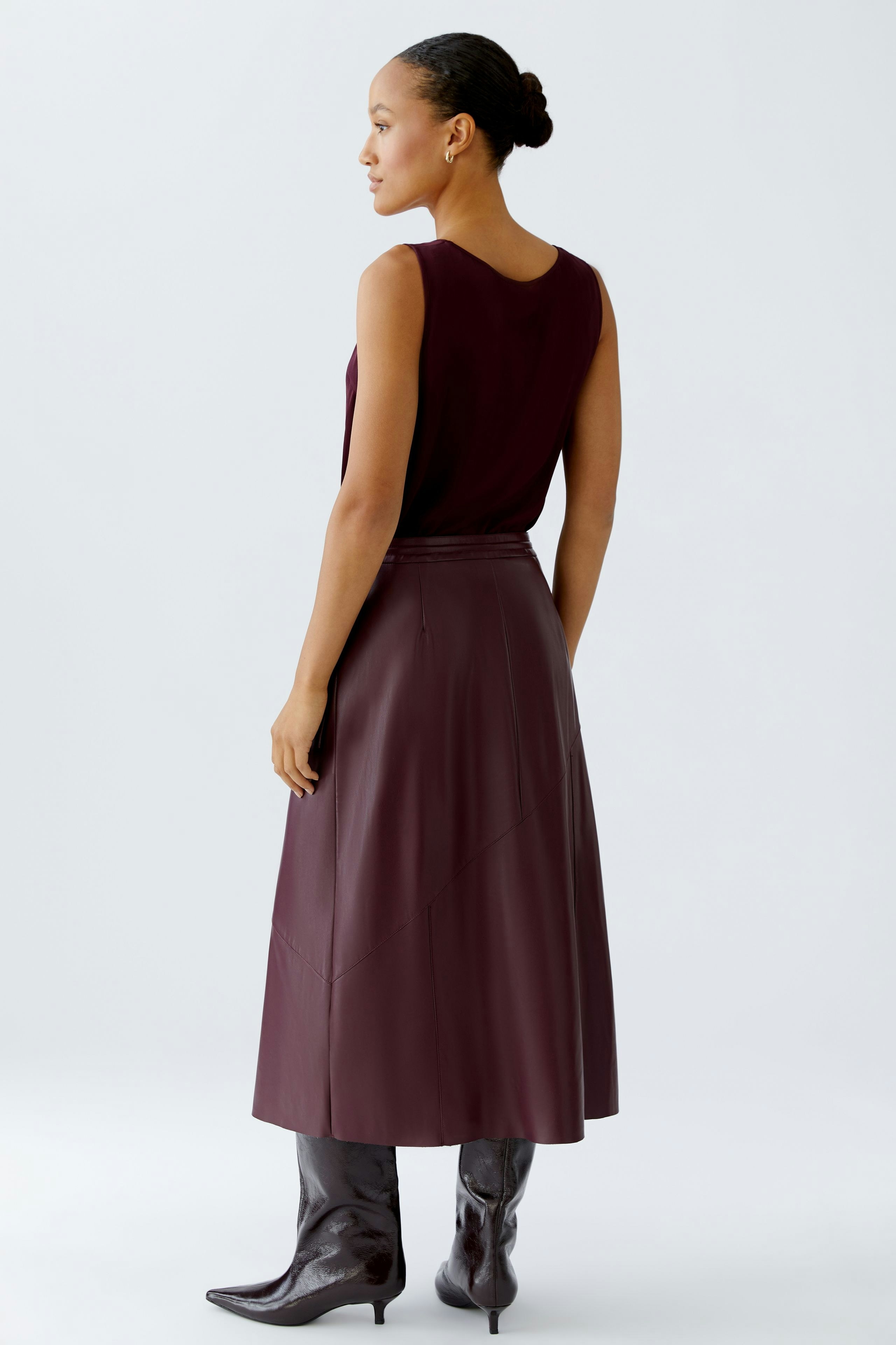 Wrap skirt: A woman in a burgundy wrap skirt paired with stylish knee-high boots.