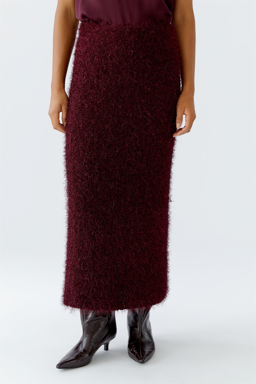 Cozy women's knit skirt in burgundy, paired with stylish boots, perfect for casual outings.