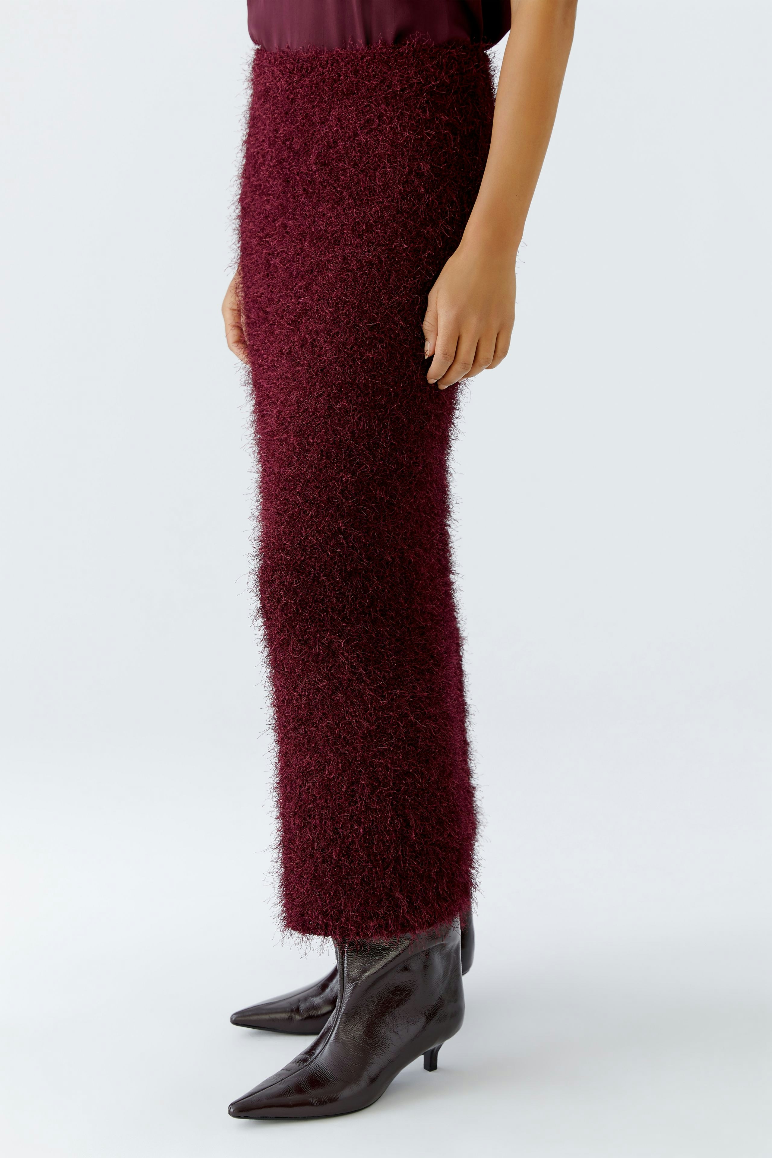 Damen-Strickrock in Bordeaux: Frau trägt einen flauschigen, langen Rock mit schmalem Schnitt und Stiefeln.