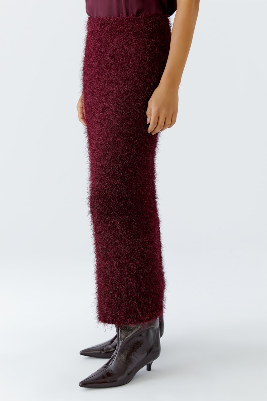 Cozy women's knit skirt in burgundy, paired with stylish boots.