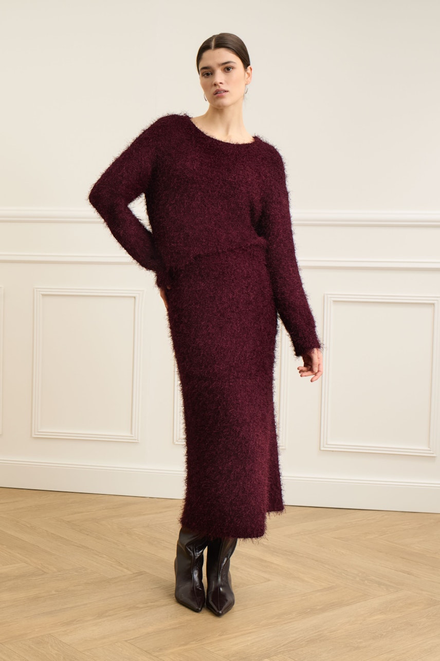 Cozy women's knit skirt in burgundy, paired with a matching pullover for a relaxed look.