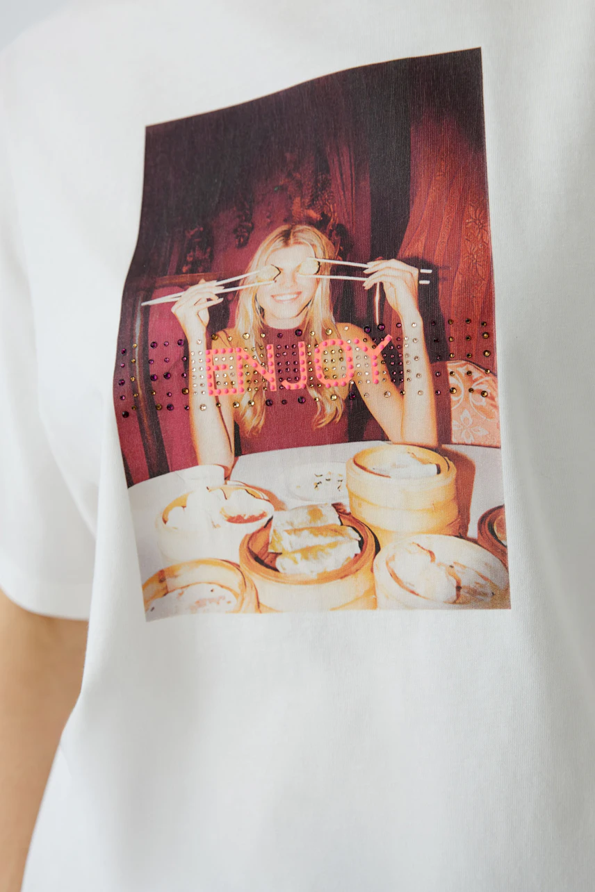 Damen-T-Shirt: Frau mit Stäbchen lächelt vor einem Tisch mit Dim Sum.