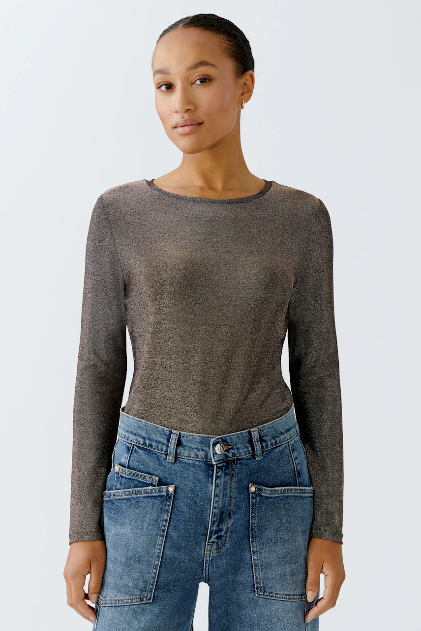 Long-sleeve shirt: Woman in a shimmering brown top paired with casual blue jeans.