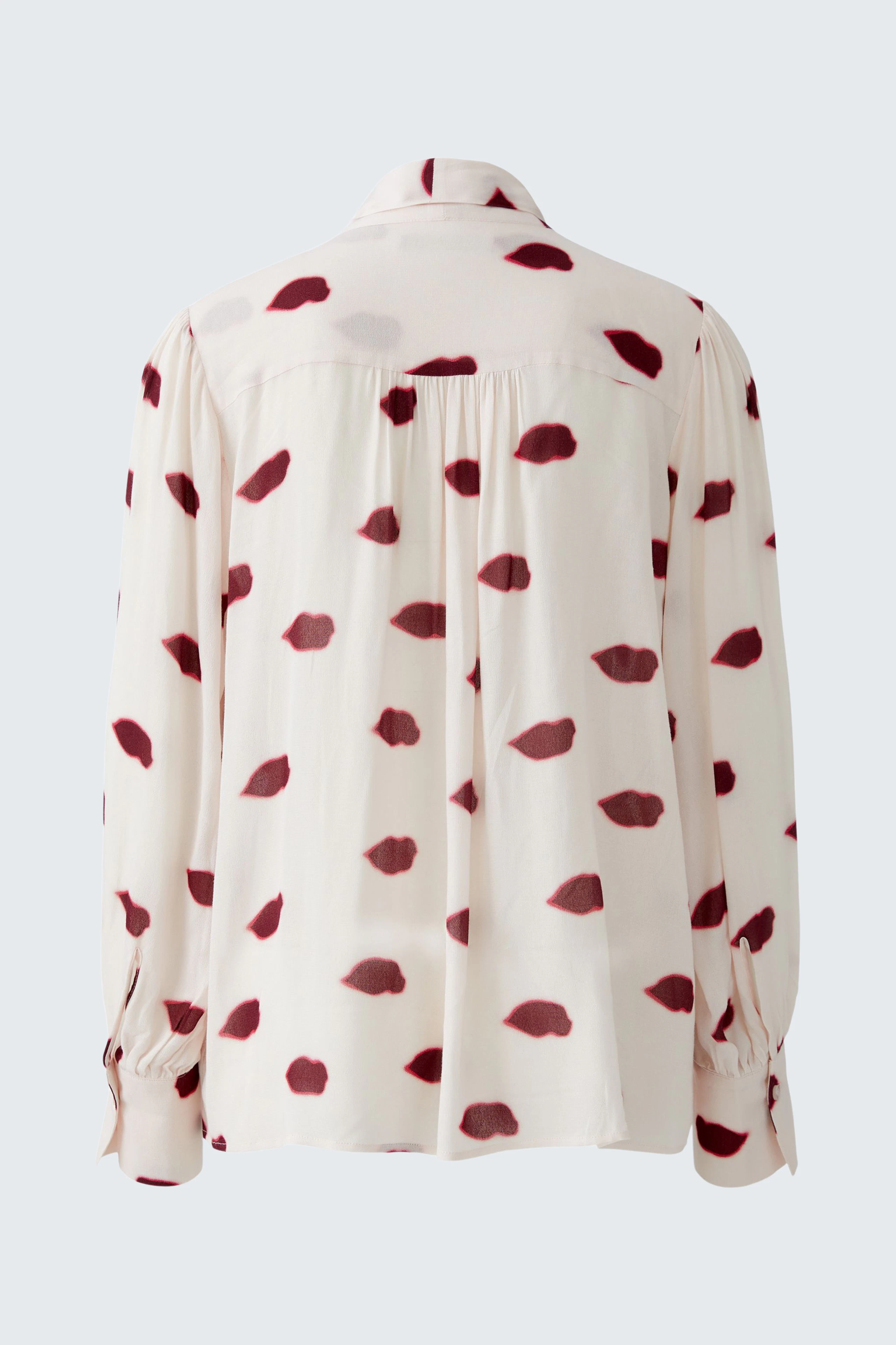 Casual women's blouse: Back view of a cream blouse with red spots, featuring a relaxed fit and button details.