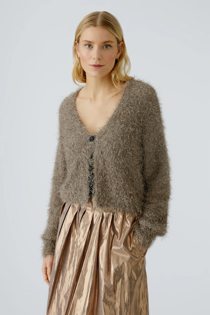 Damen-Strickjacke: Frau in flauschiger, brauner Strickjacke mit Knöpfen und lässigem Rock.